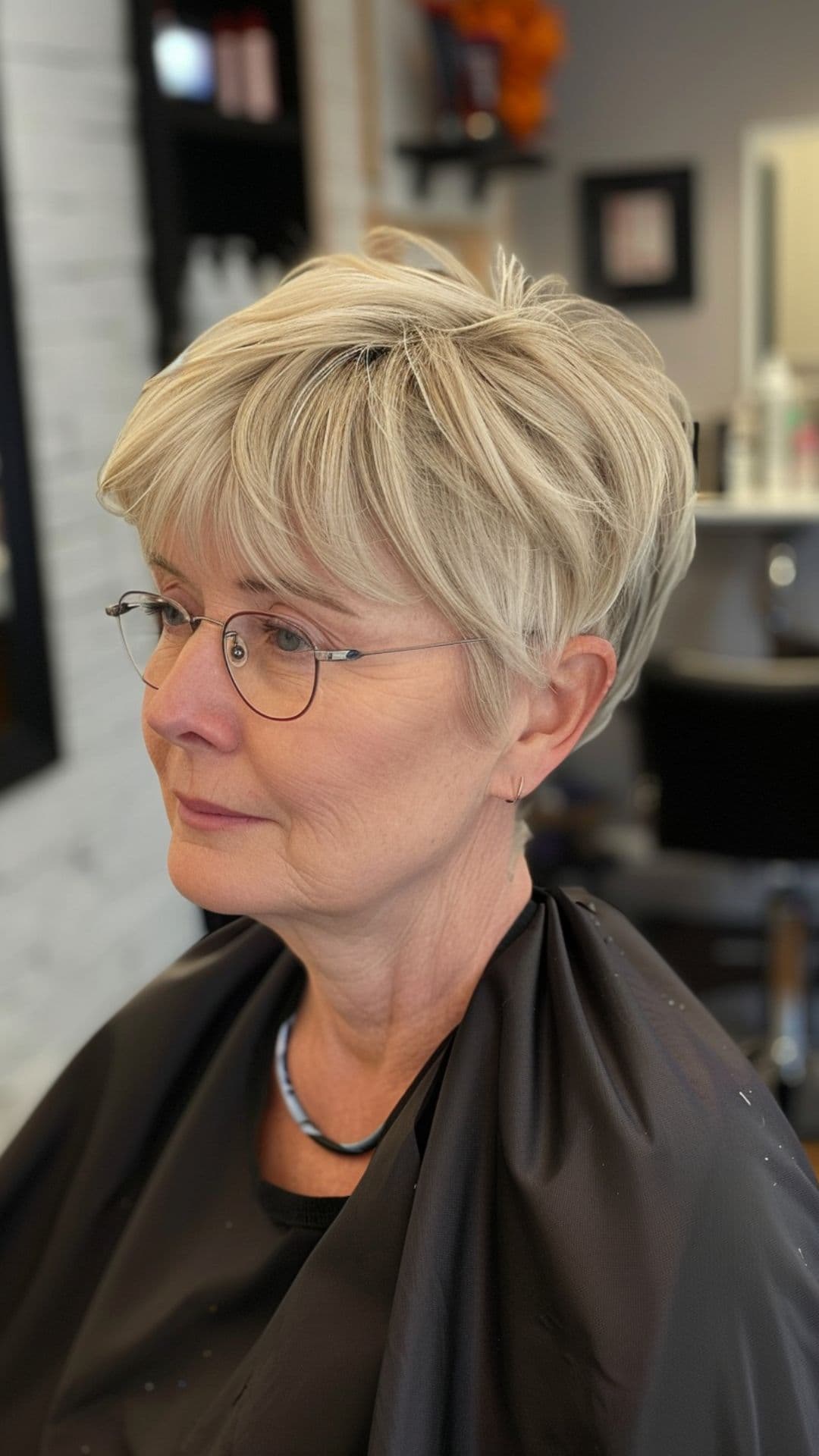 An old woman modelling an ash blonde pixie cut.