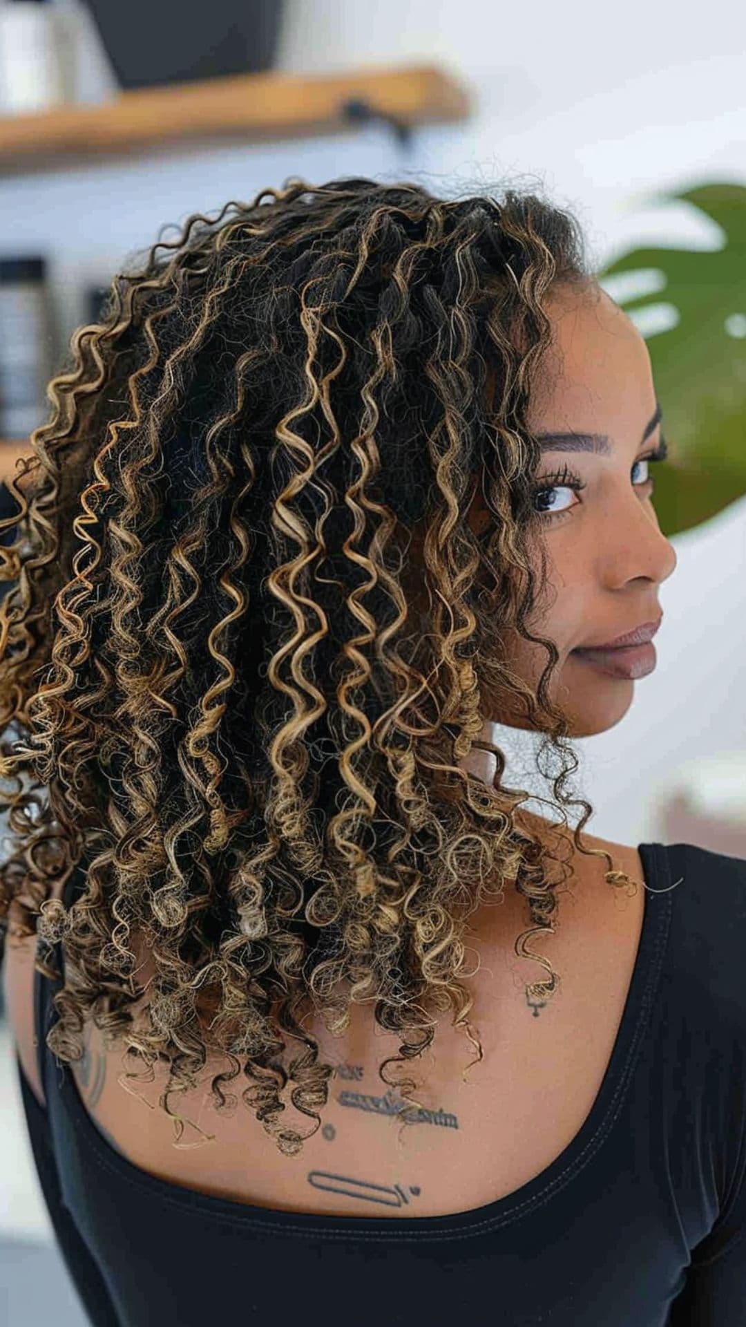 A black woman modelling a honey blonde highlights on afro hair.