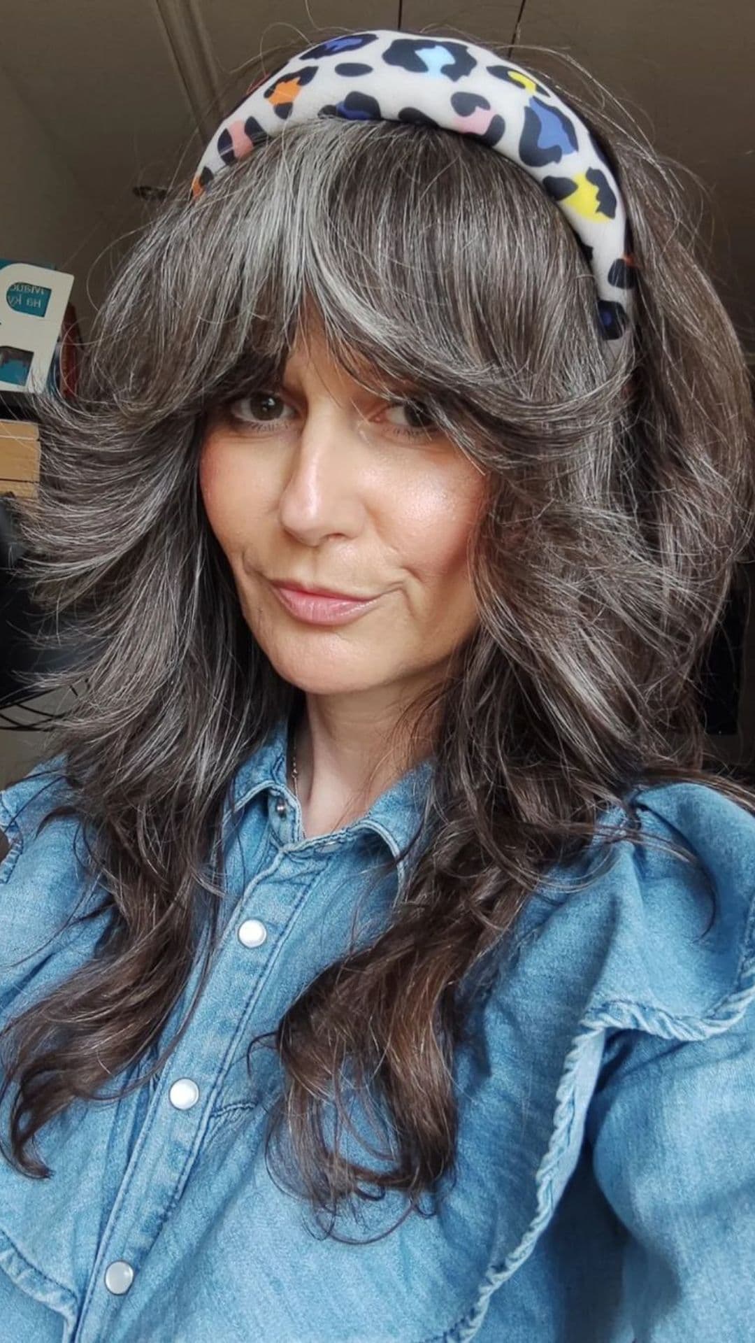 An older woman modelling a feathered bangs hairstyle.