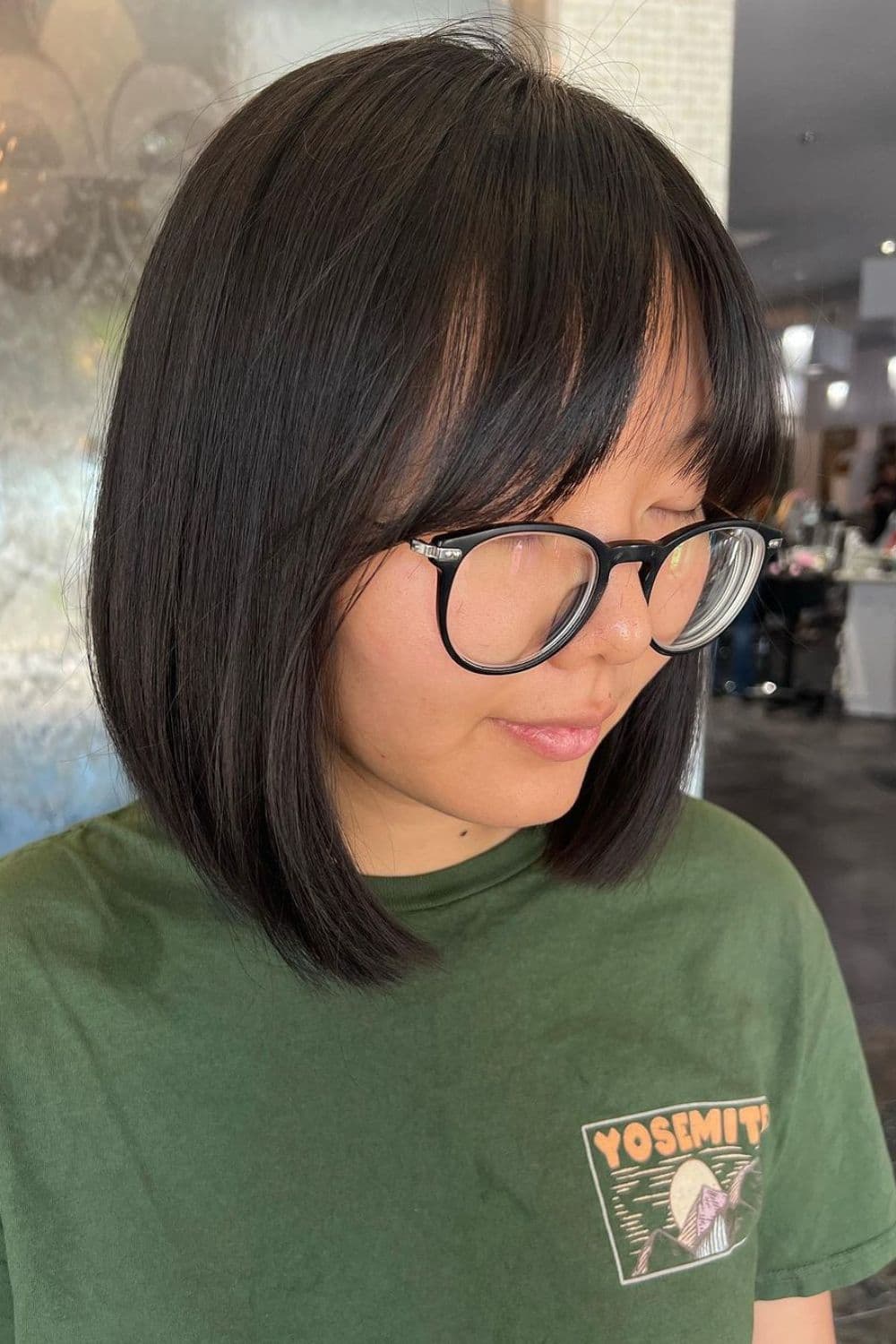 A woman wearing eyeglasses with a black A-line bob.