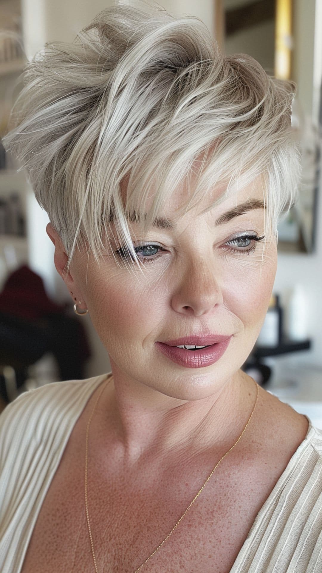 A woman modelling an ash blonde pixie cut.