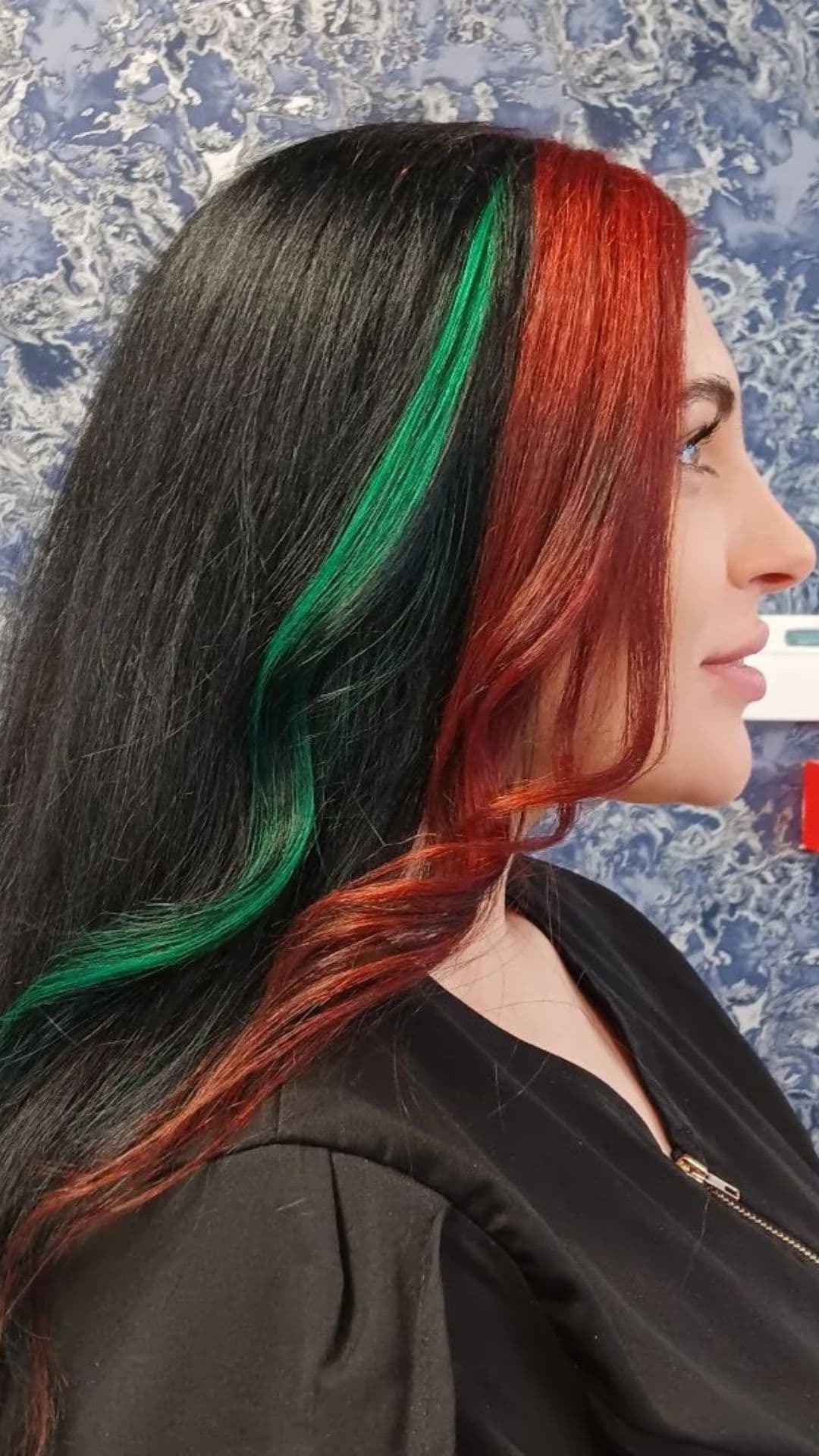 A woman modelling a Black Hair with Red and Green Moneypieces hair.