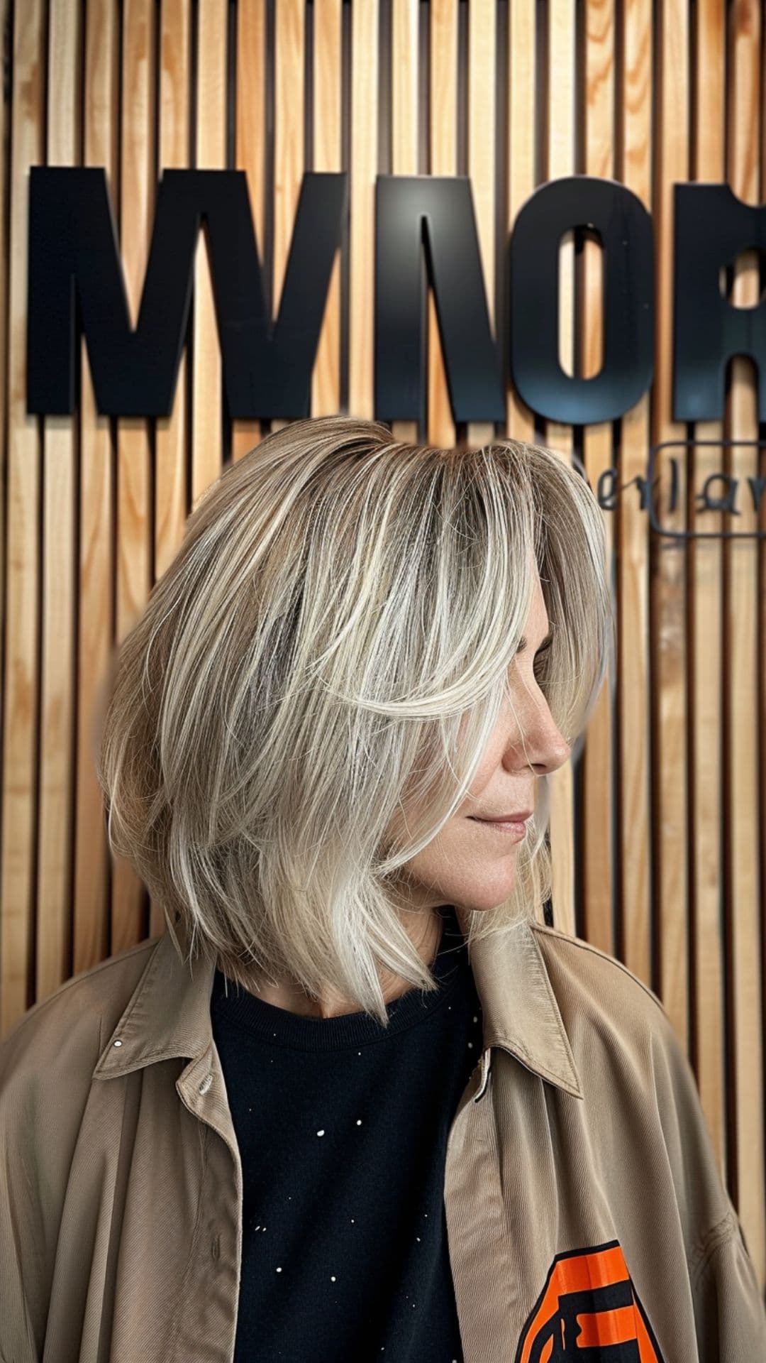 An old woman modelling a blonde bob with curtain bangs.