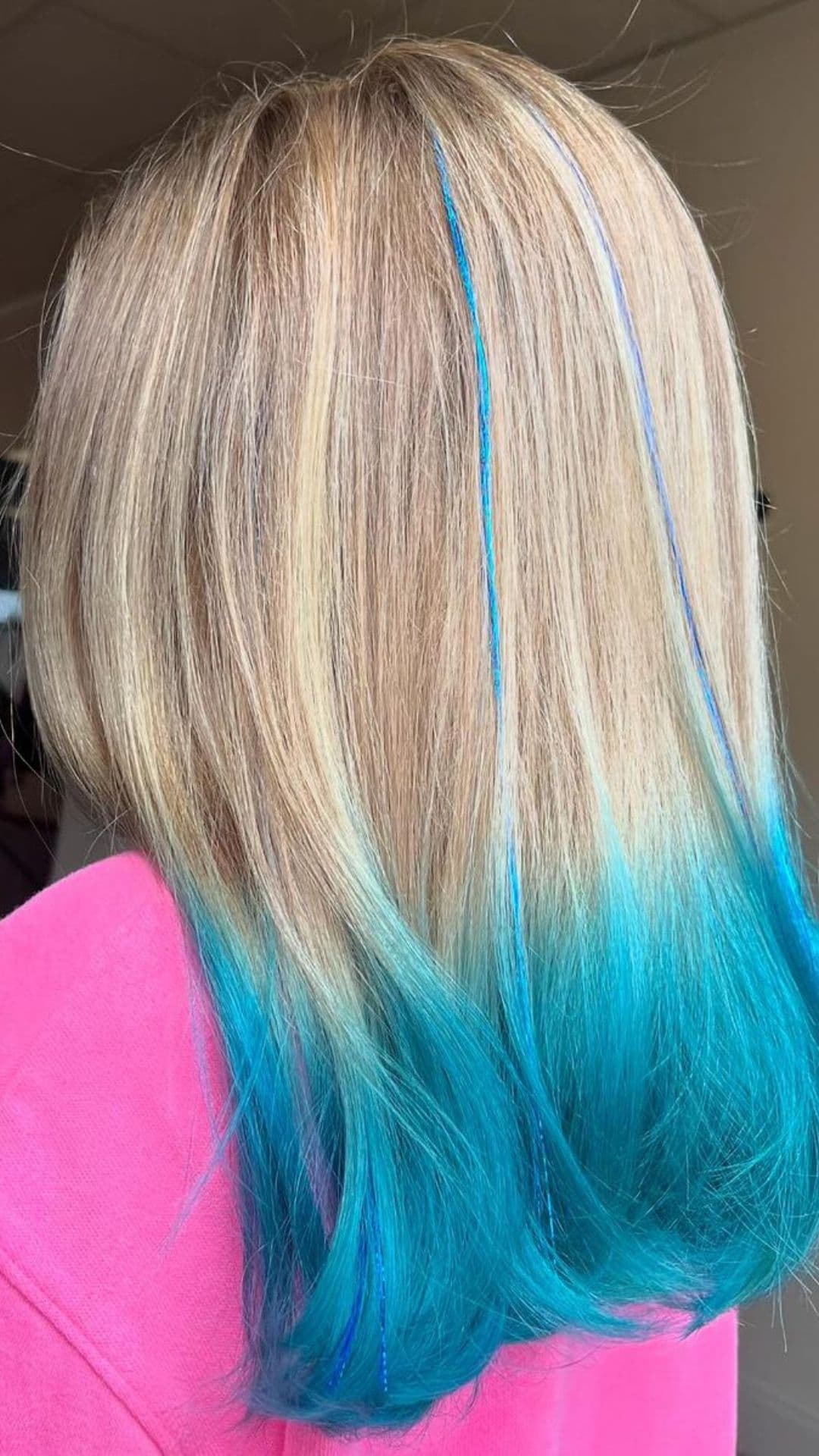 A woman modelling a blonde to aqua blue ombre.