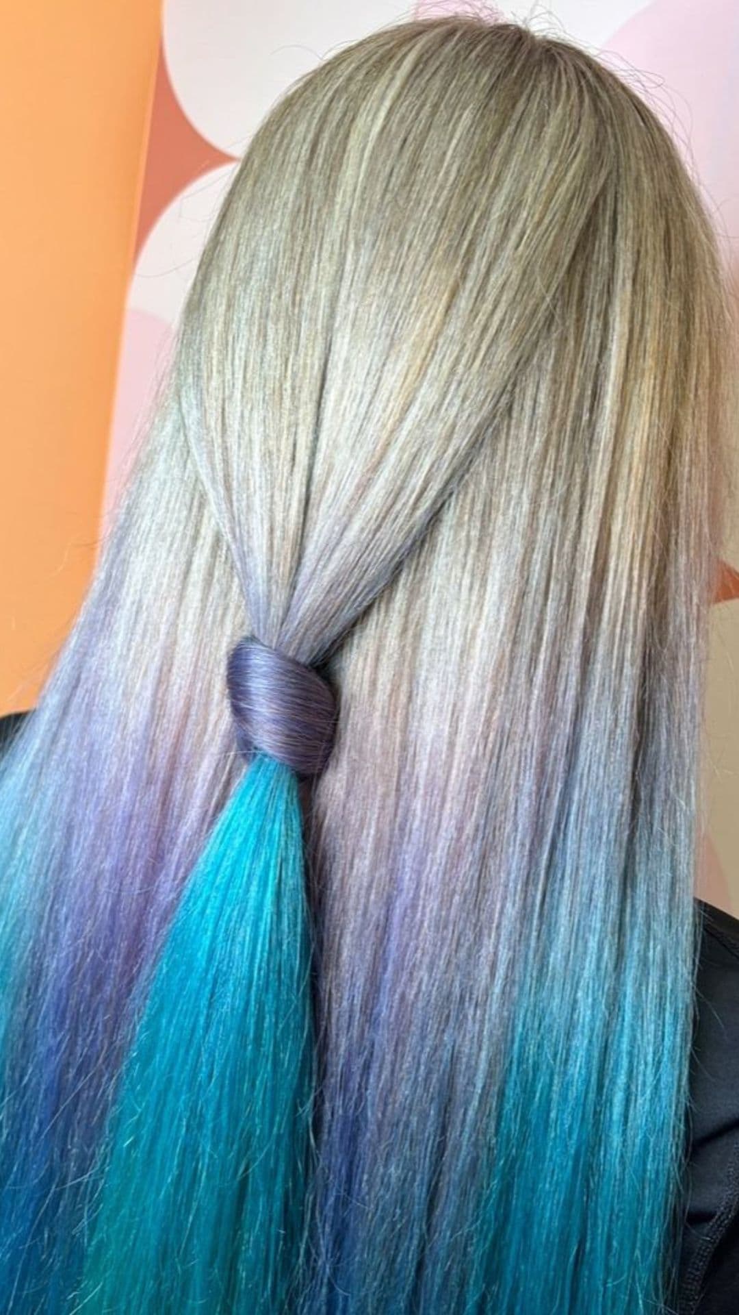 A woman modelling a blonde to mermaid hair ombre.