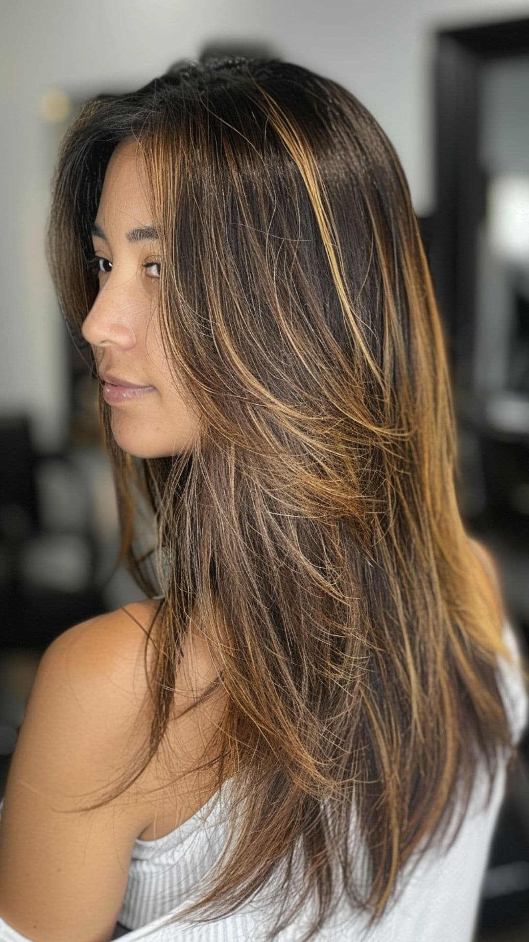 A woman modelling a caramel and espresso balayage hair.