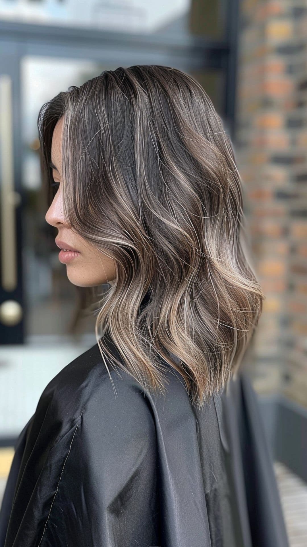 A woman modelling a chocolate balayage medium-length hair.