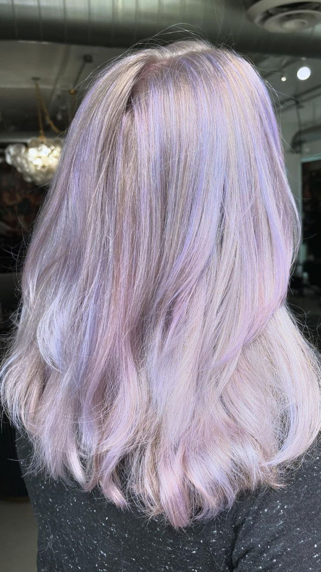 Here’s your alt text: A person with shoulder-length hair styled in Frosted Pastels, featuring shades of soft purple and lavender, shown from the back.