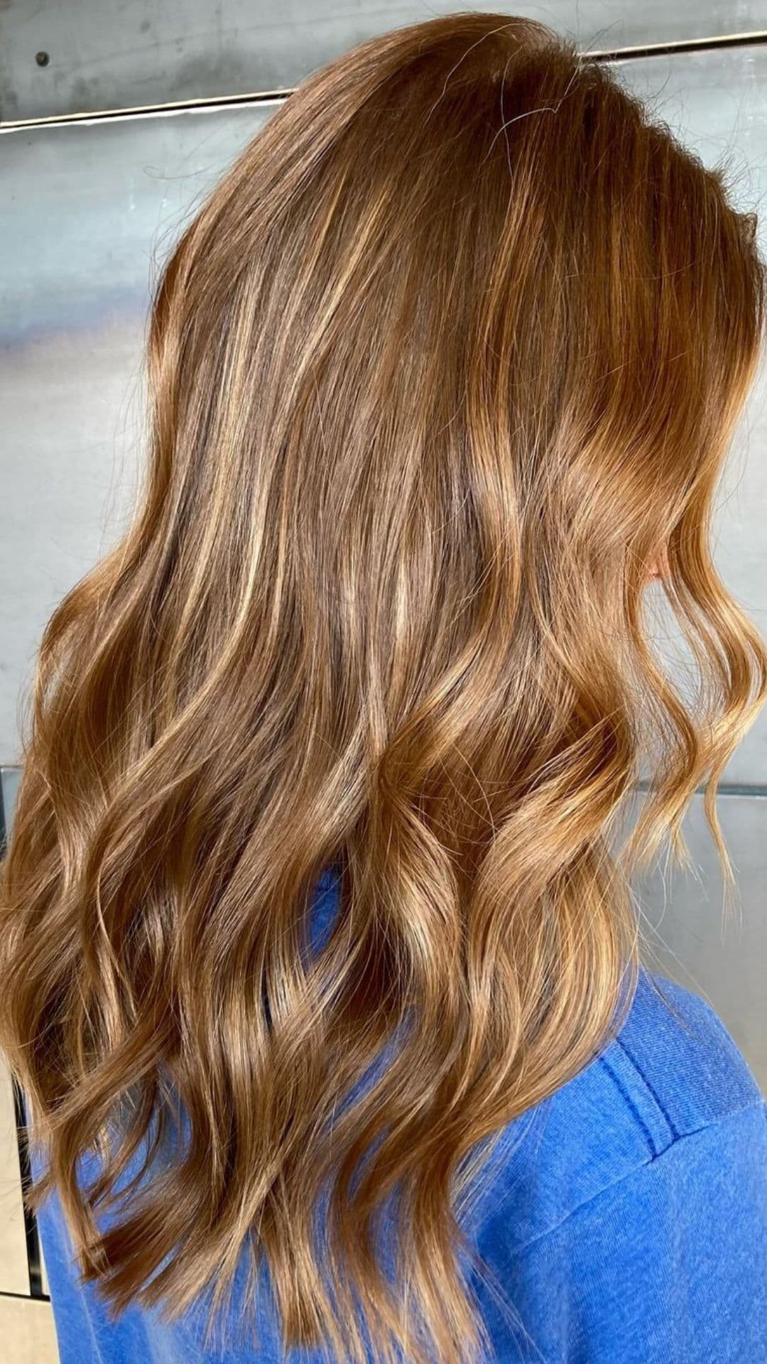 Person showing off a Gingerbread Brown hairstyle with soft waves.