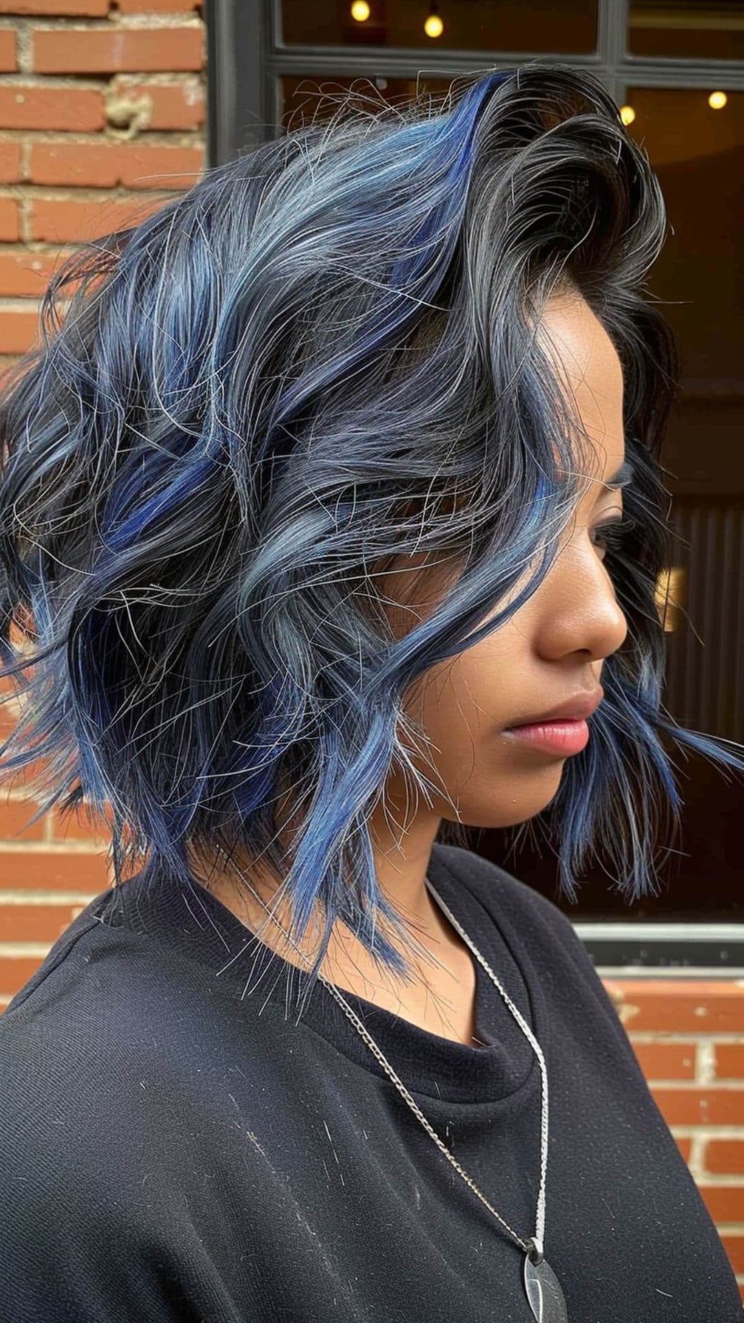 A woman modelling a black hair with icy blue highlights.