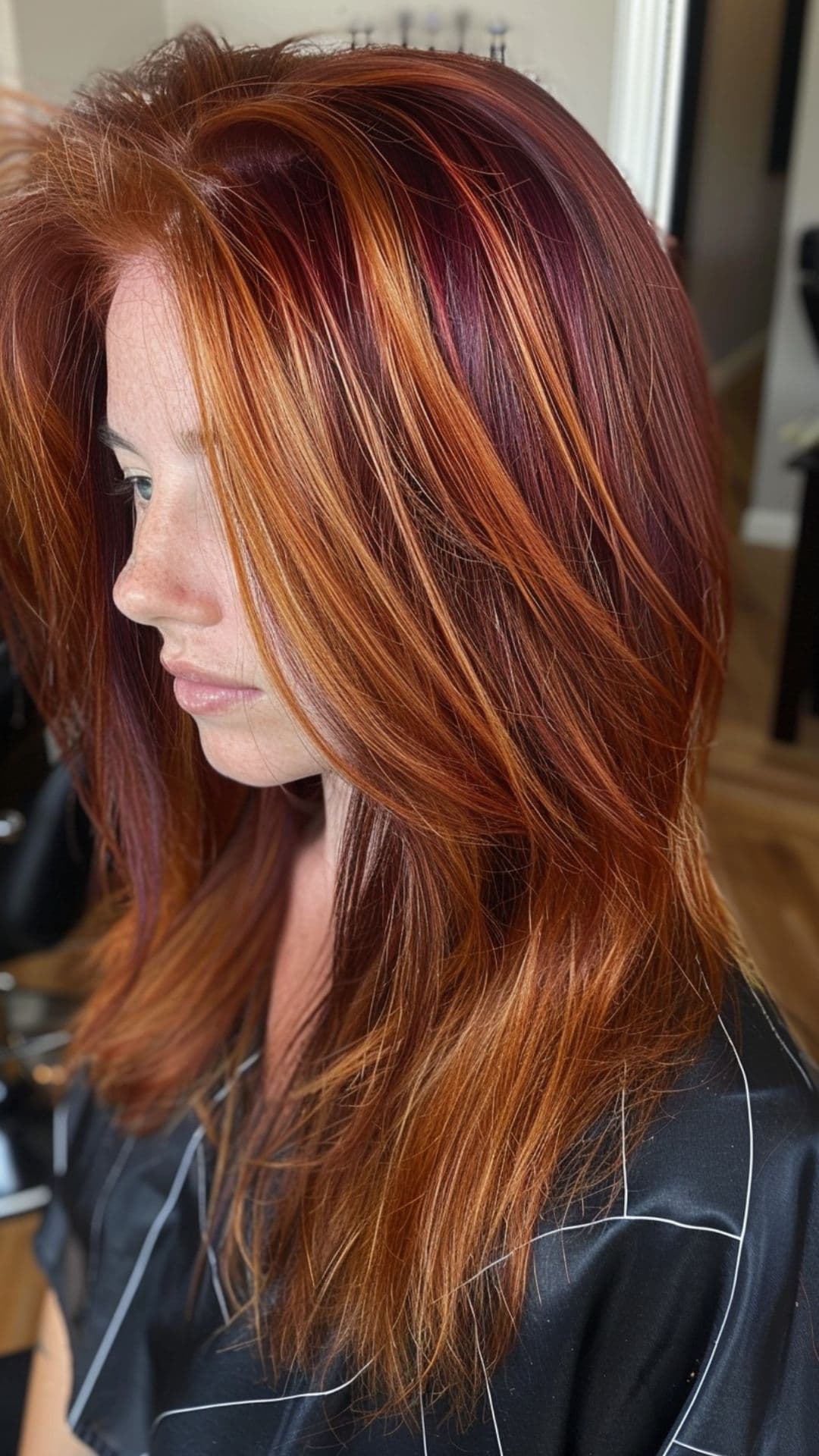 A woman modelling a copper chunky highlights on a red violet hair.