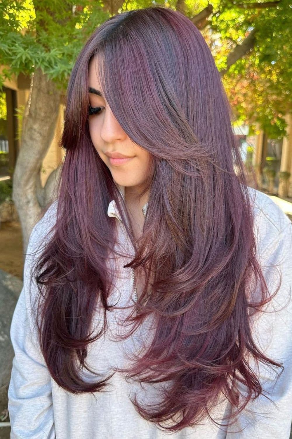 A woman with long front layers with curtain bangs.