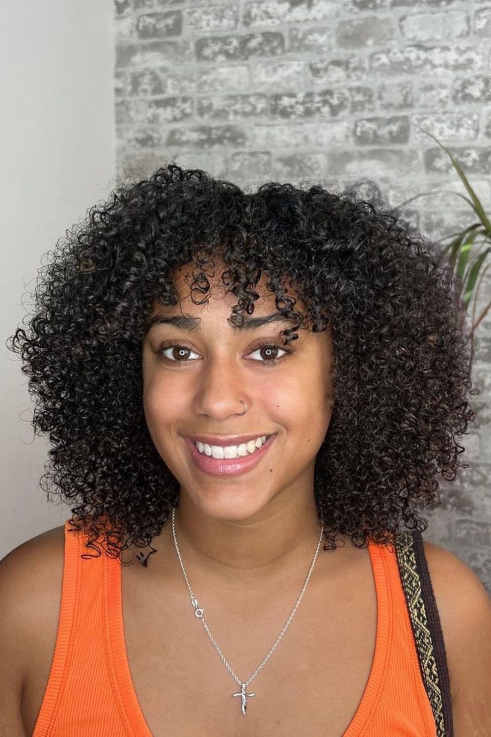 A black woman with a curly deva cut.