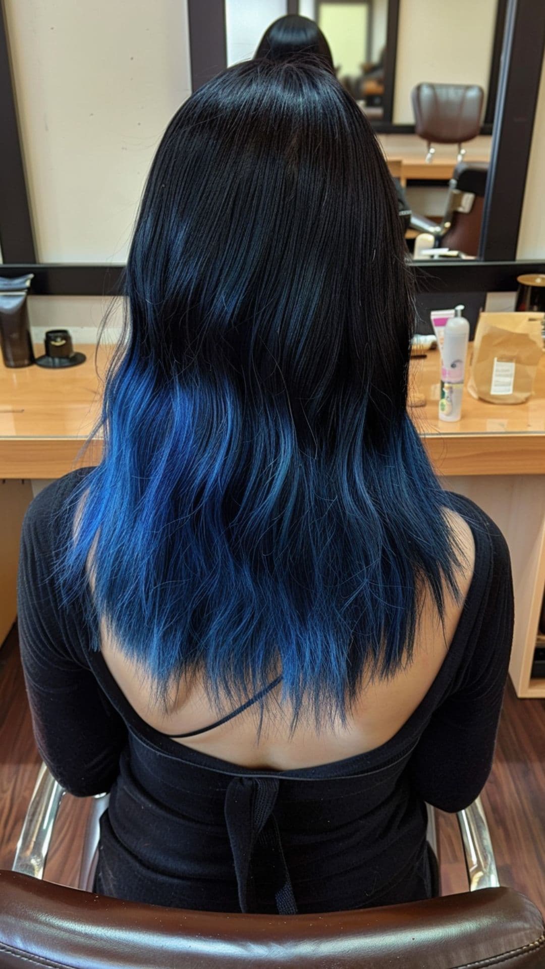 A woman modelling a black to electric blue ombre hair.