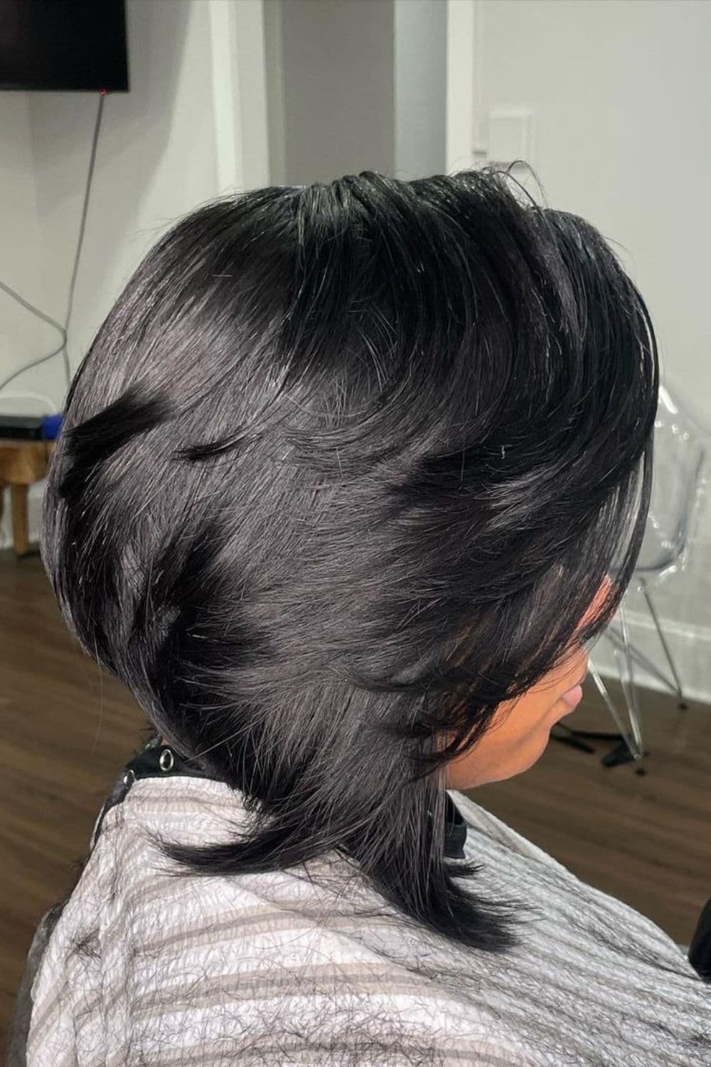 A woman with a black feathered asymmetrical bob.