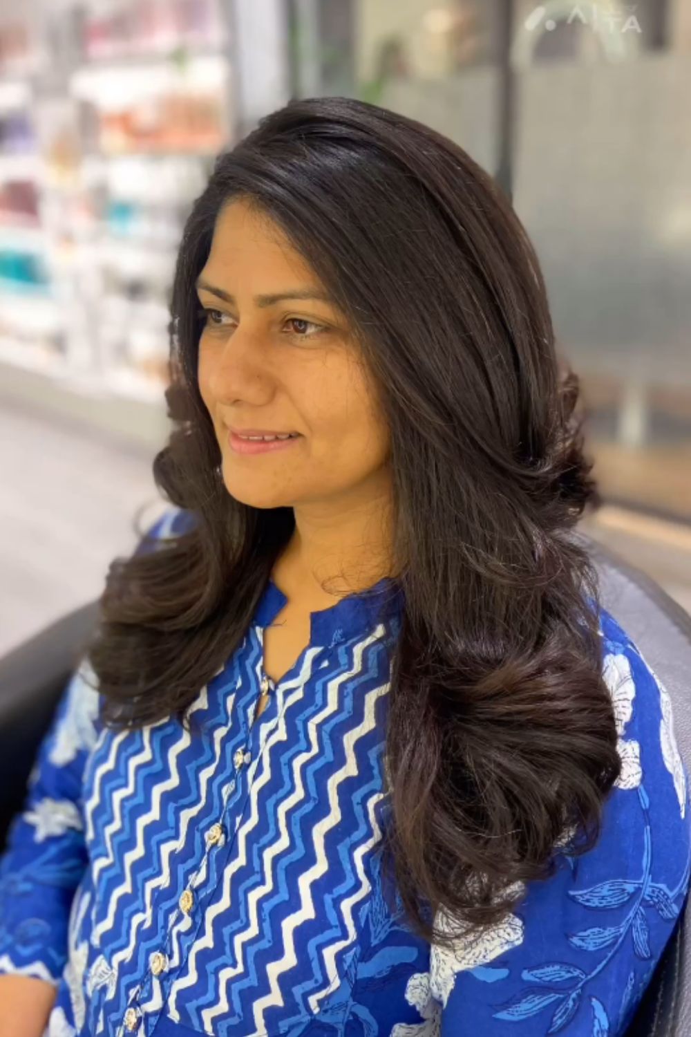 A woman with long black feathered butterfly layers.