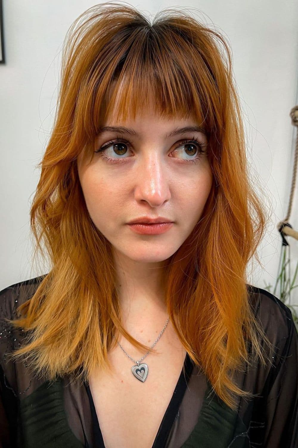 A woman with a medium-length feathered shag.