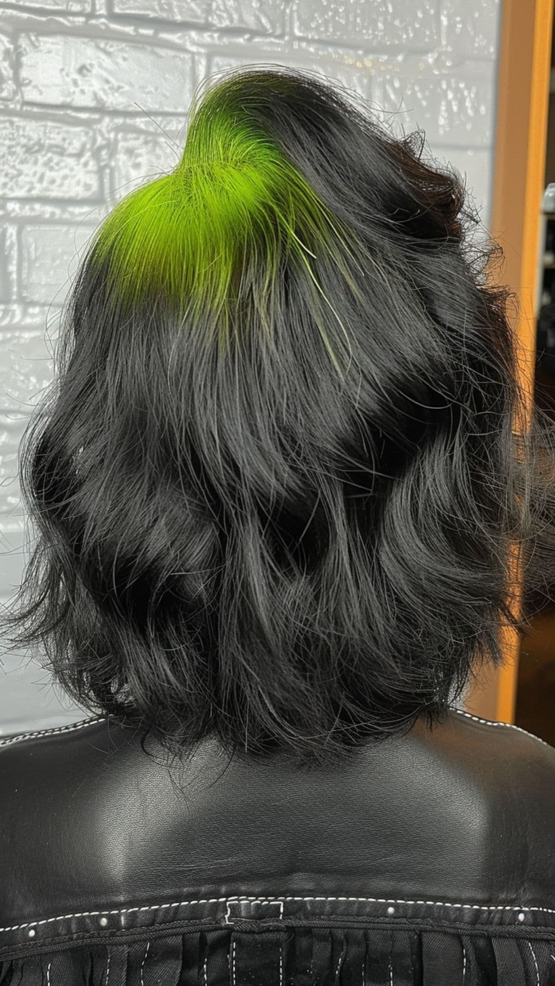 A woman modelling a green roots on black hair.