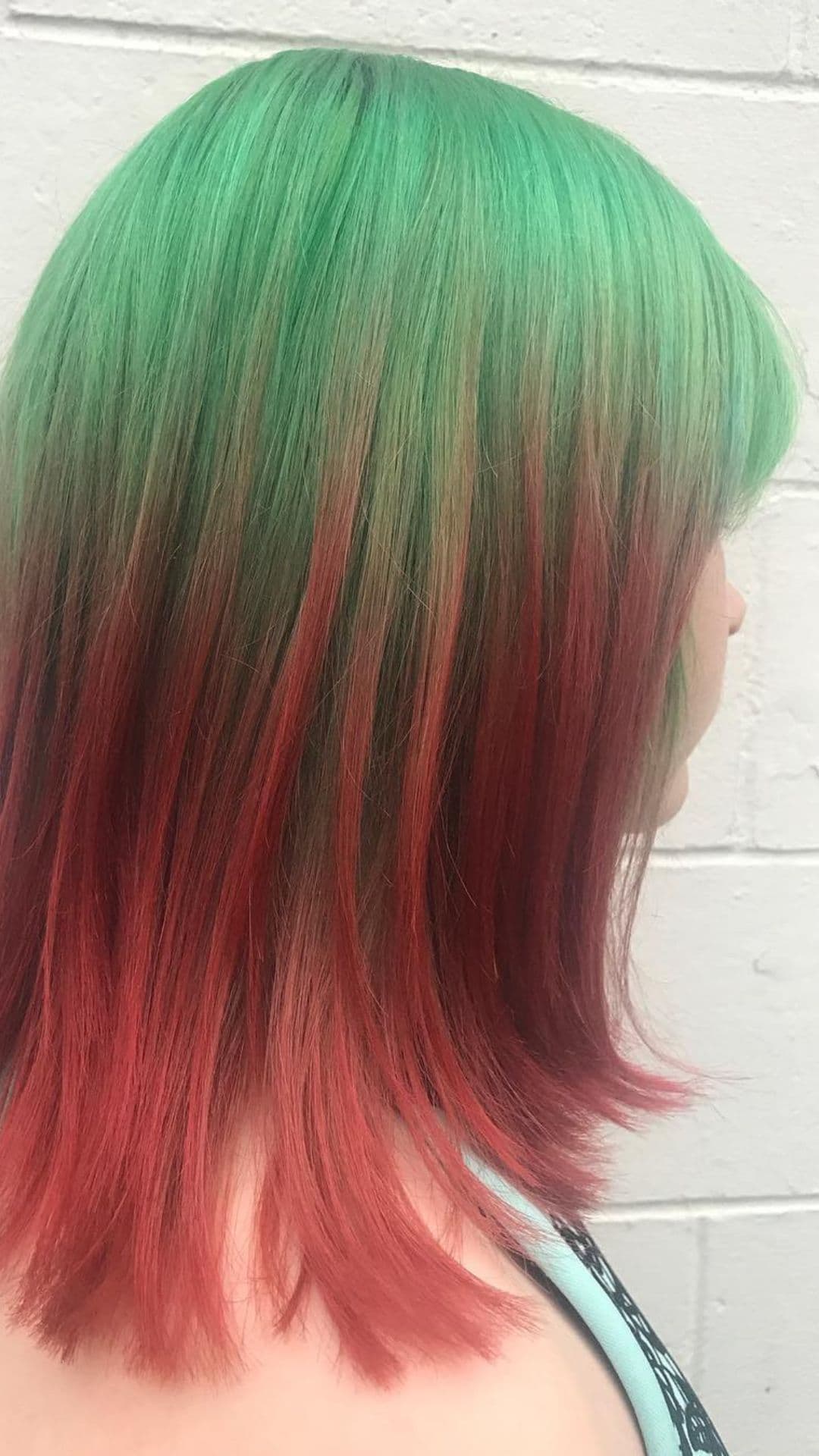 A woman modelling a Green to Red Ombre hairstyle.