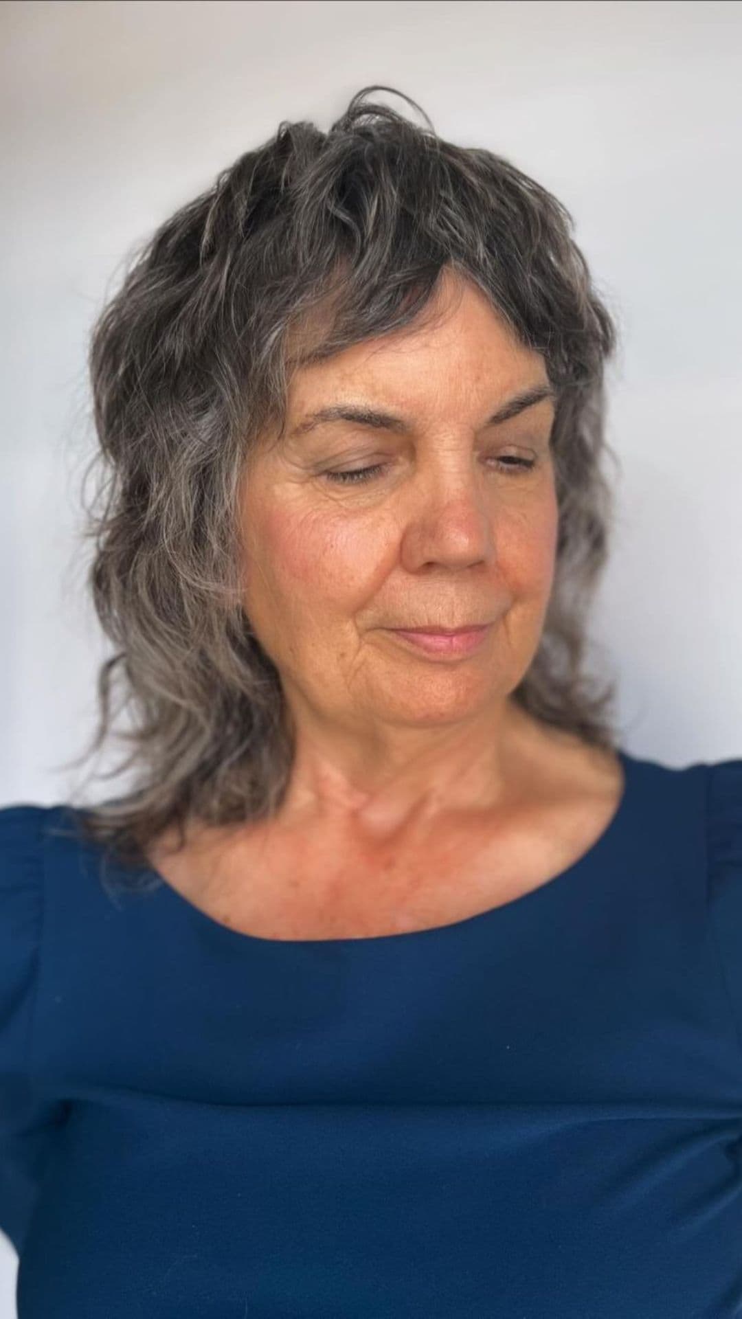 An old woman modelling a grey razor cut shag hairstyle.