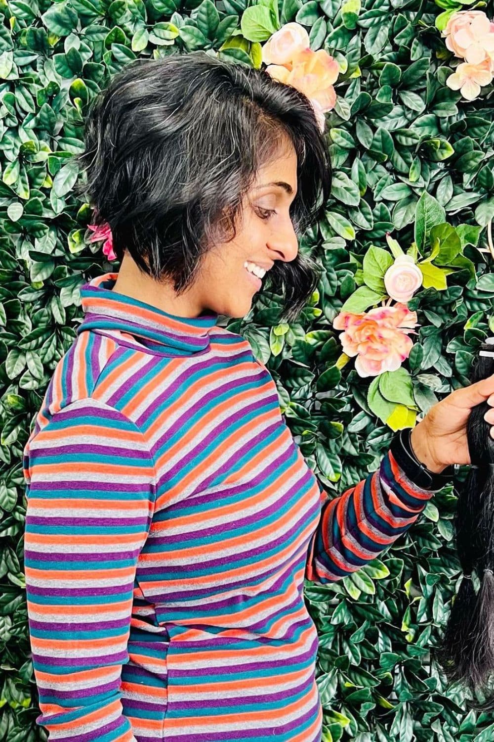 A woman wearing a striped turtleneck long sleeve with wavy inverse bob cut.