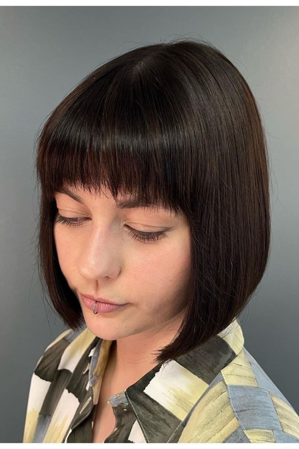 A woman with a black inverted bob cut.