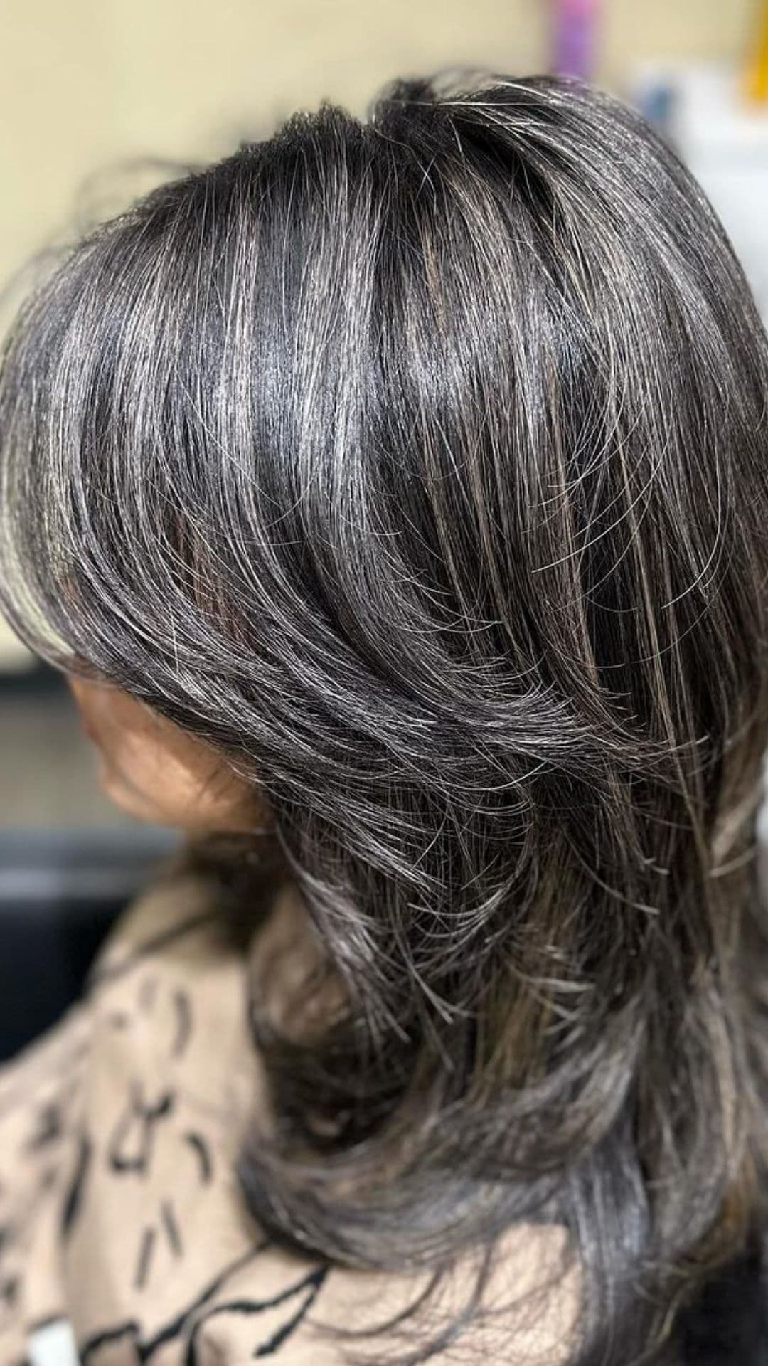 A woman modelling a layered hair with gray highlights.