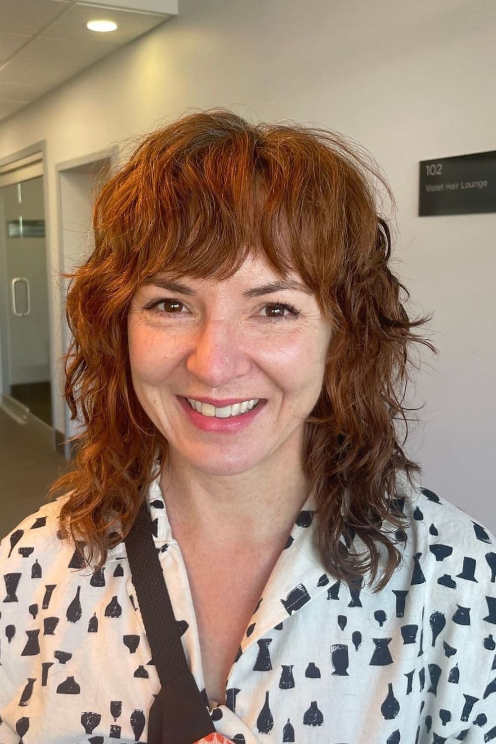 A woman with a brown curly layered shag.