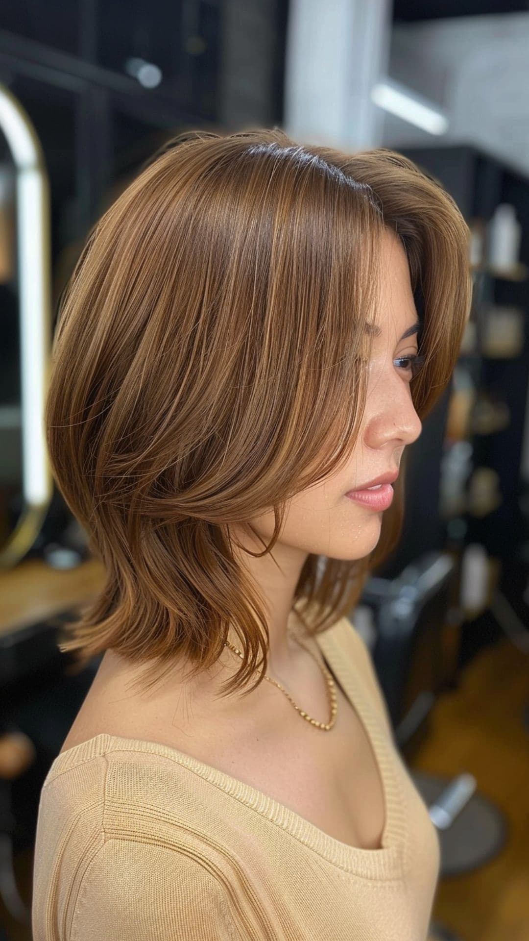 A woman modelling a light honey tea brown short hair.