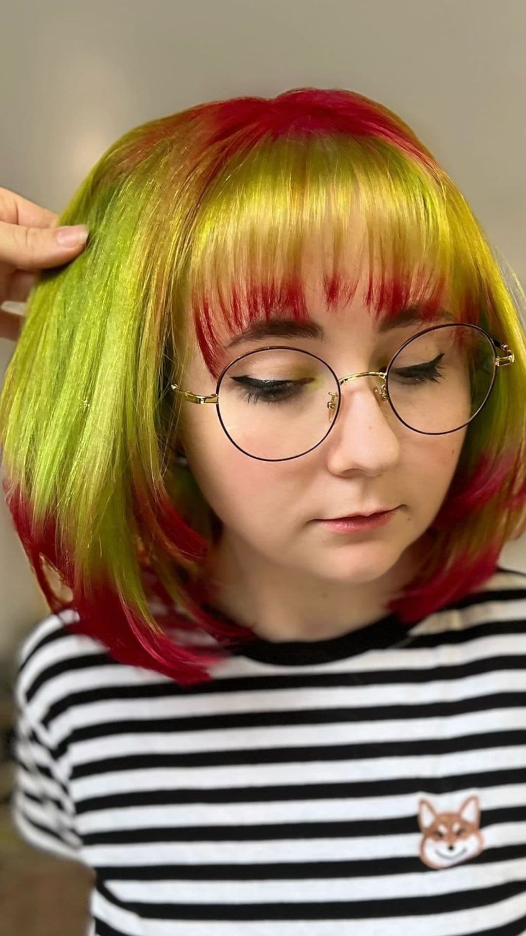 A woman modelling a Lime Green Hair with Red Dip-Dye and Red Roots hairstyle.