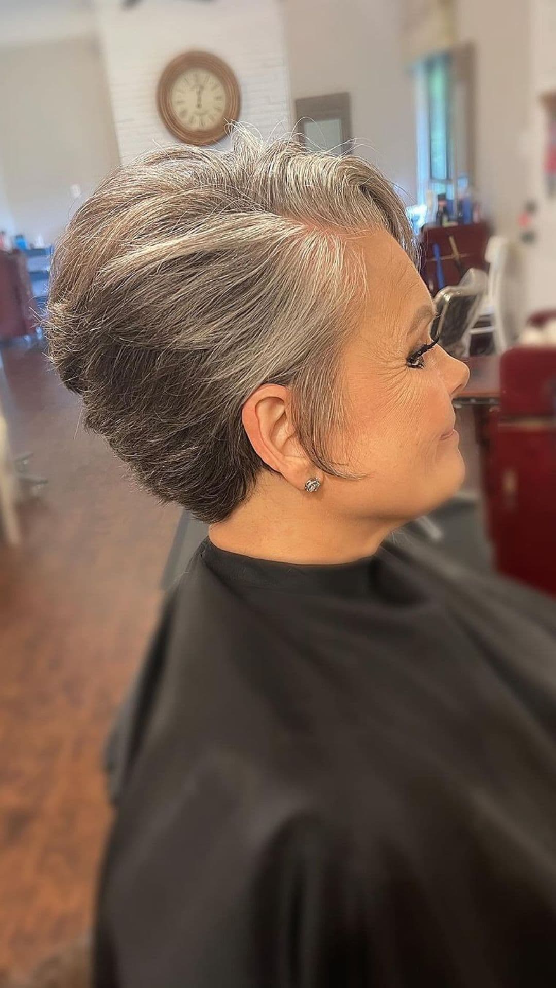 An older woman modelling a long gray pixie hairstyle.