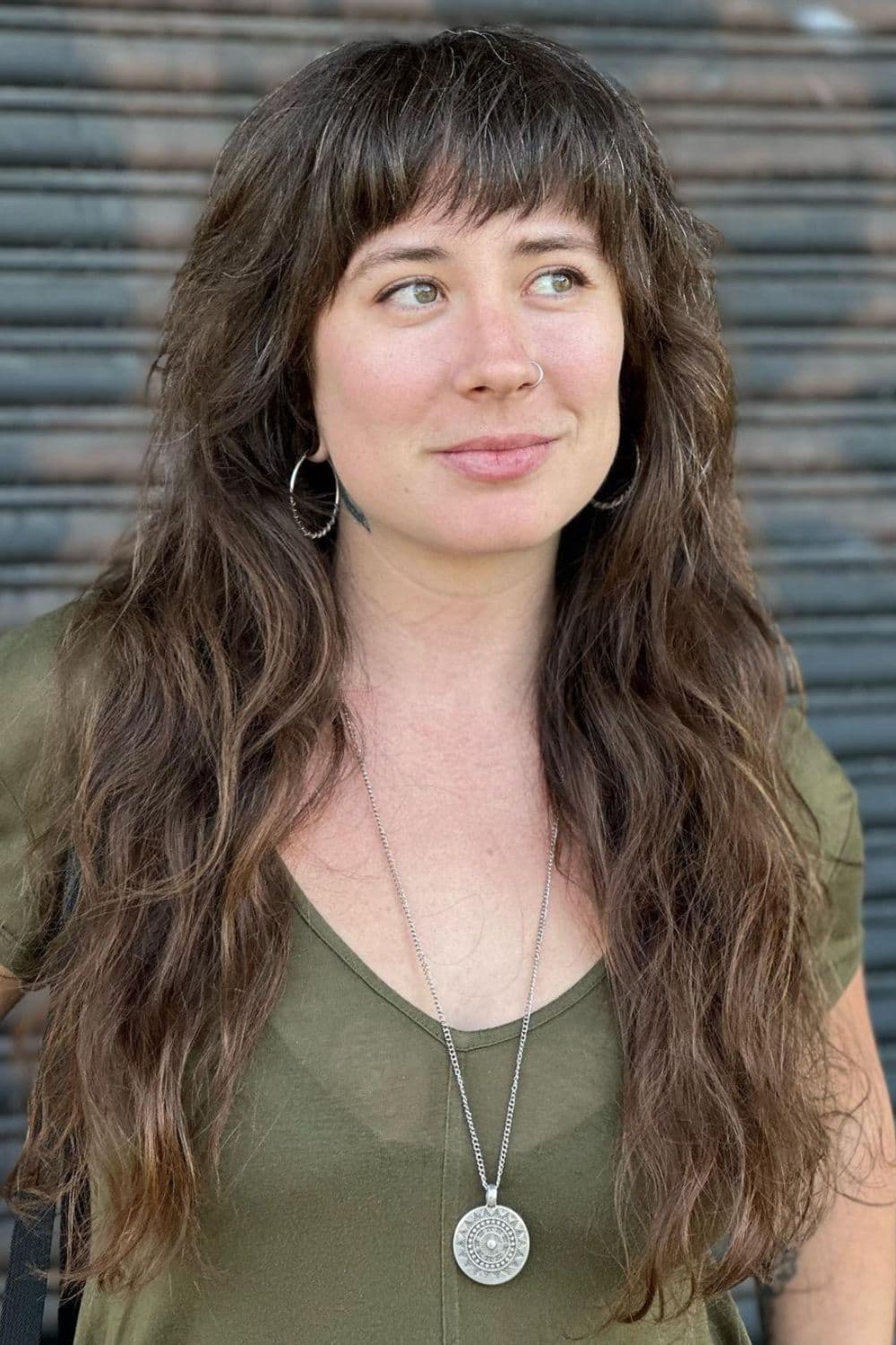 A woman with a long brown modern shag with full textured bangs.