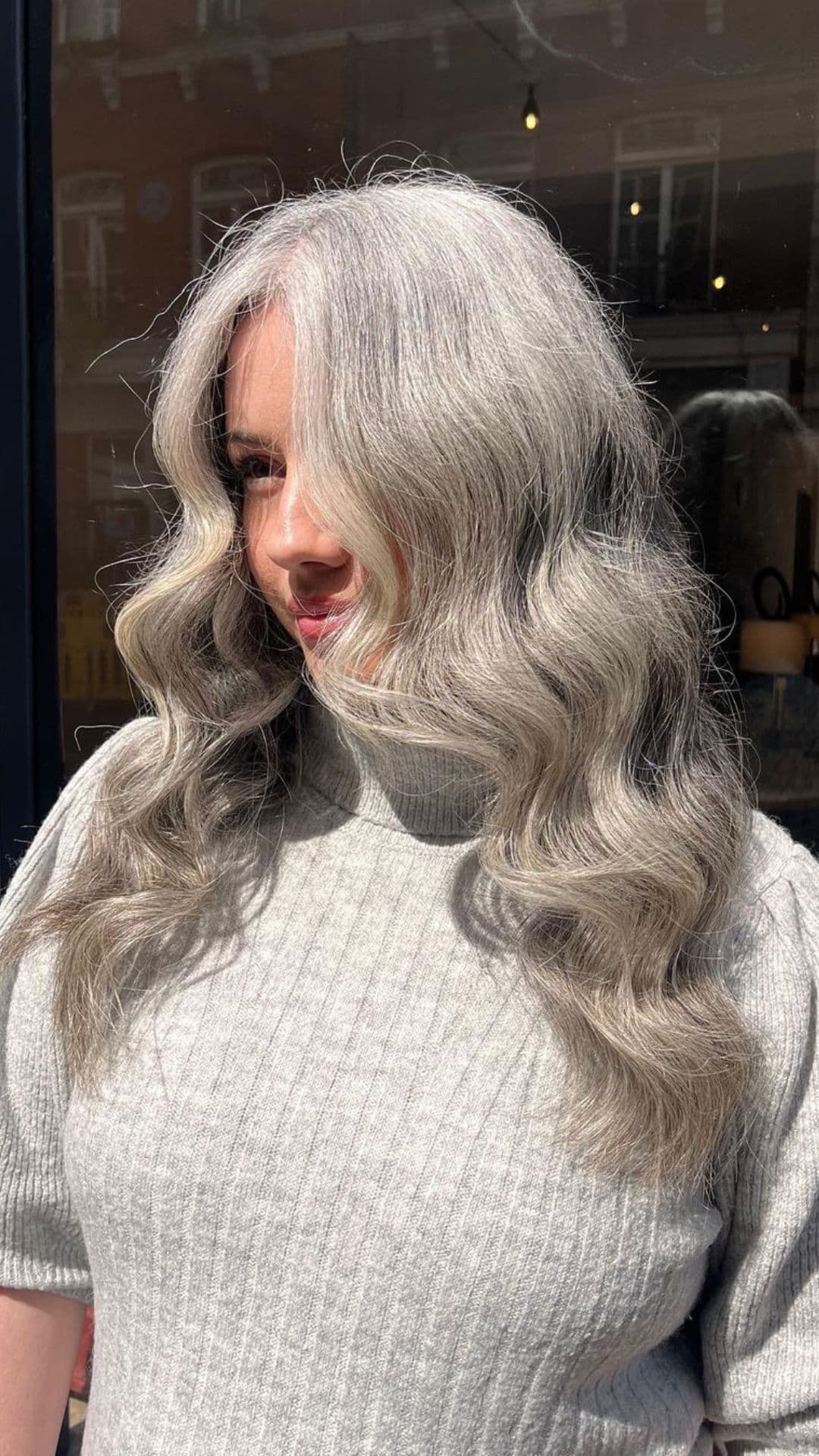 A woman modelling a long wavy gray hair.