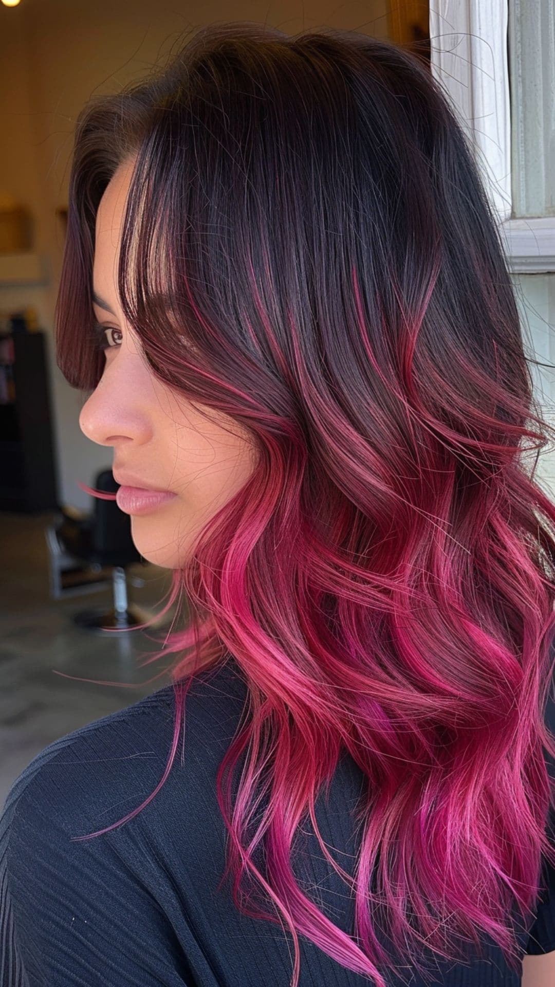 A woman modelling a black to magenta ombre hair.