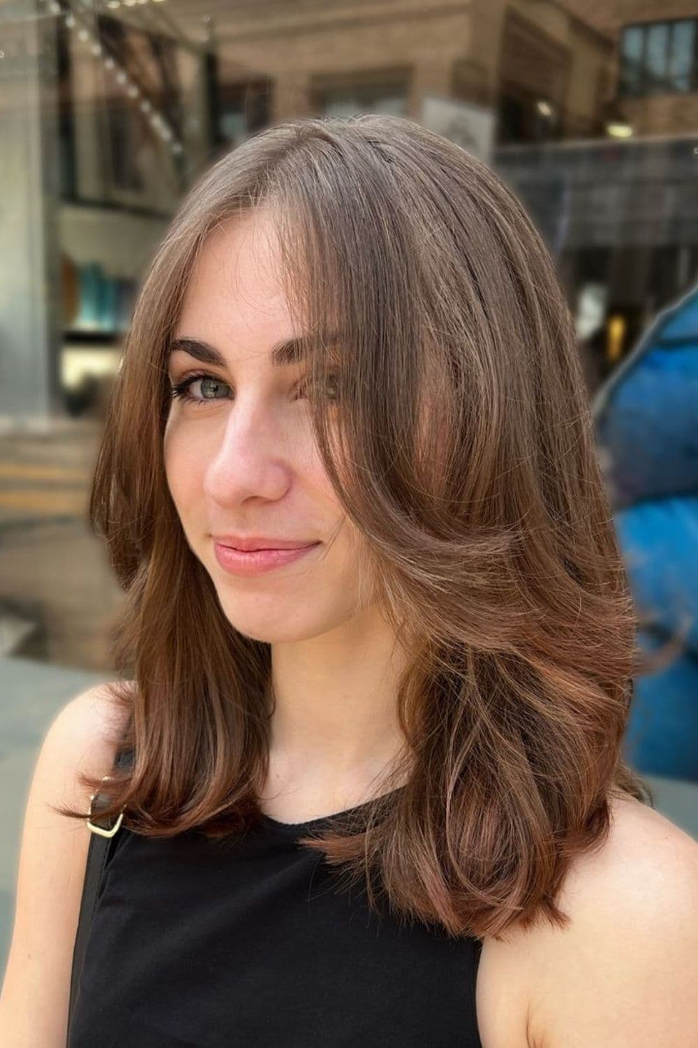 A woman with brown mid-length feathered layers.