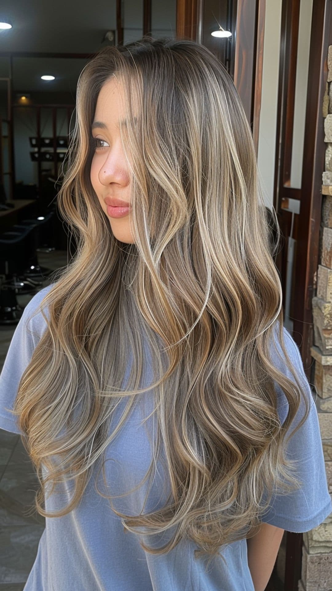 A woman modelling a milk tea ash bronde hair.