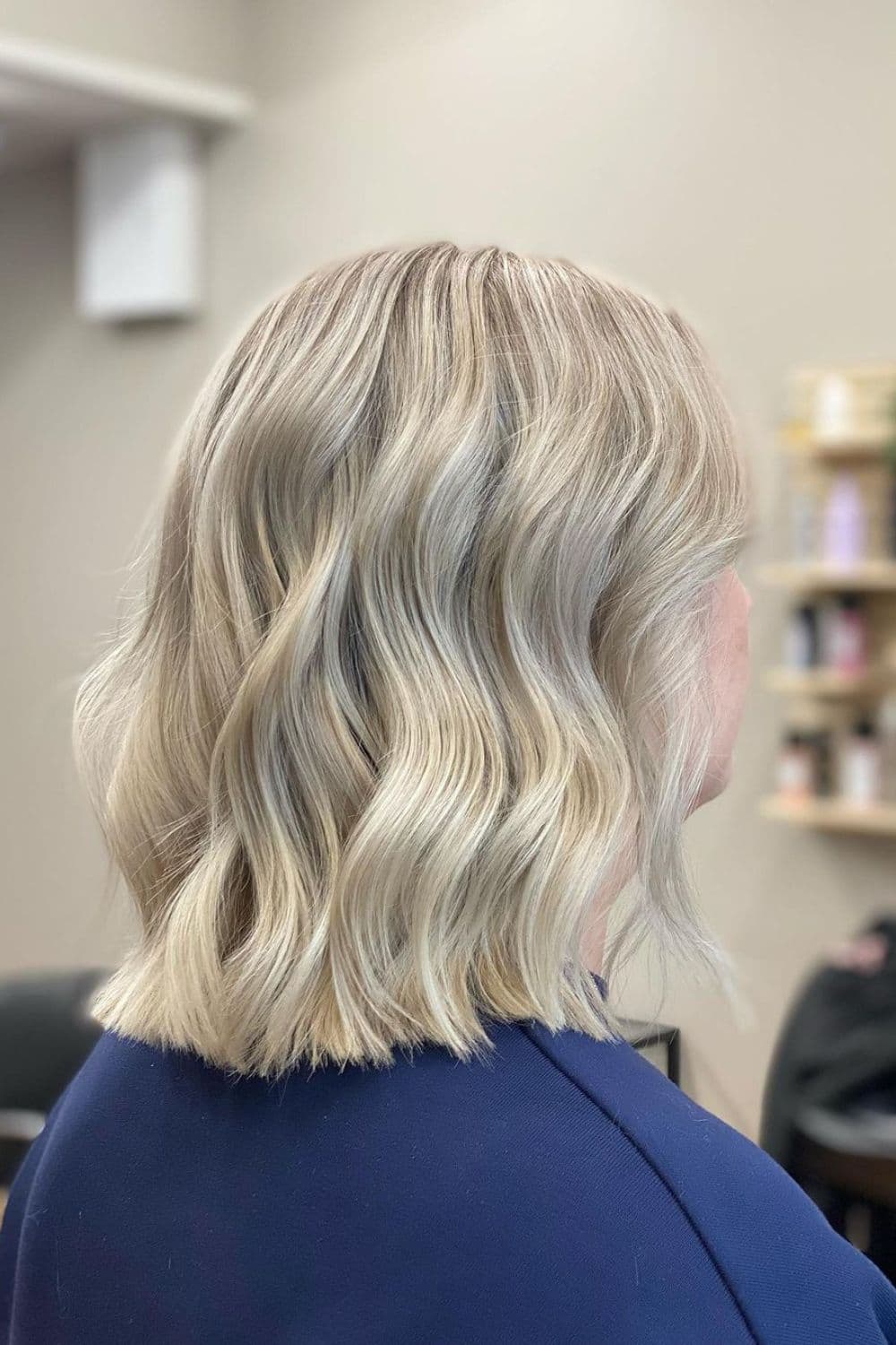 A woman with nape-length blonde wavy bob cut.