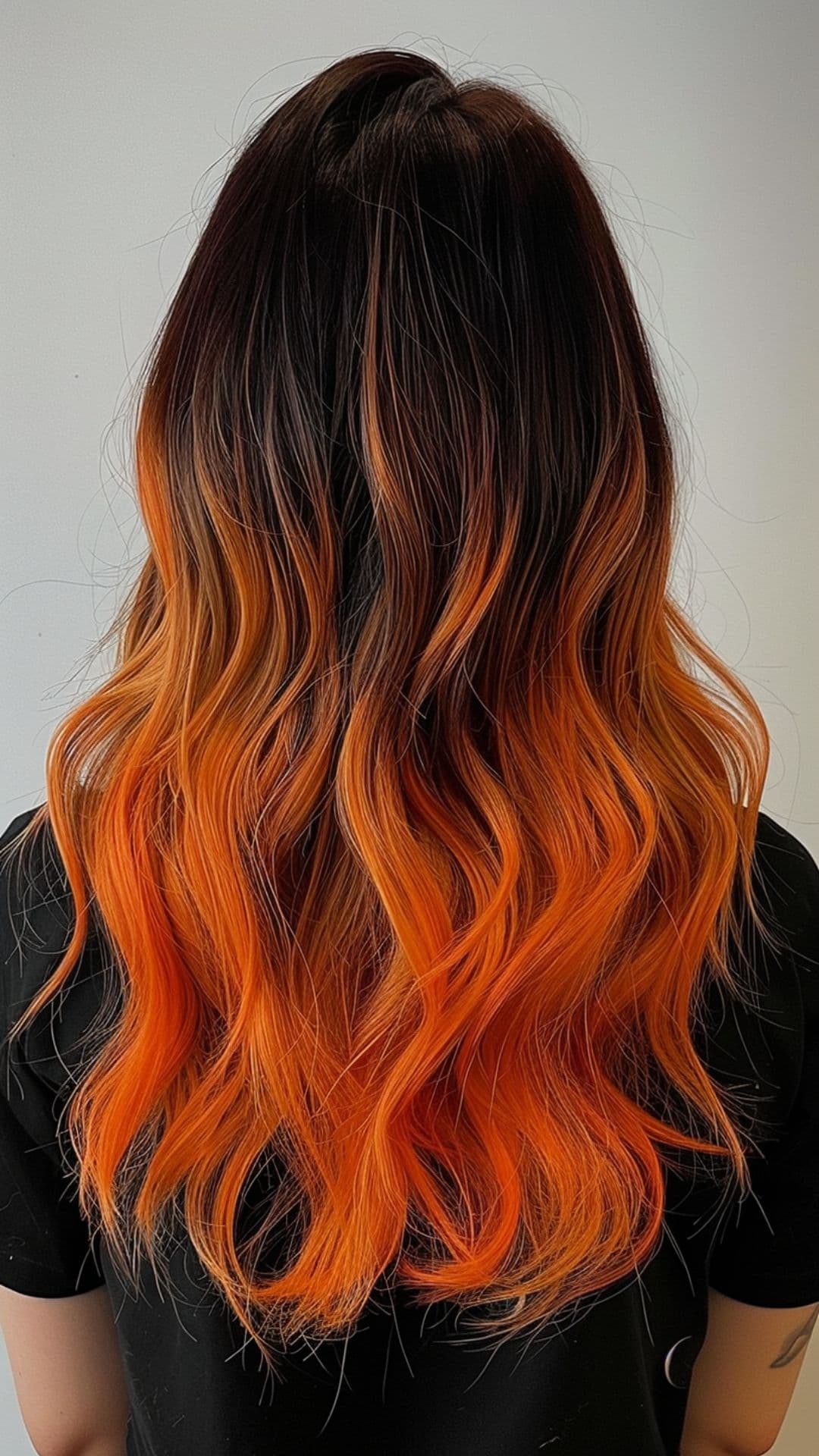 A woman modelling a black to orange ombre hair.