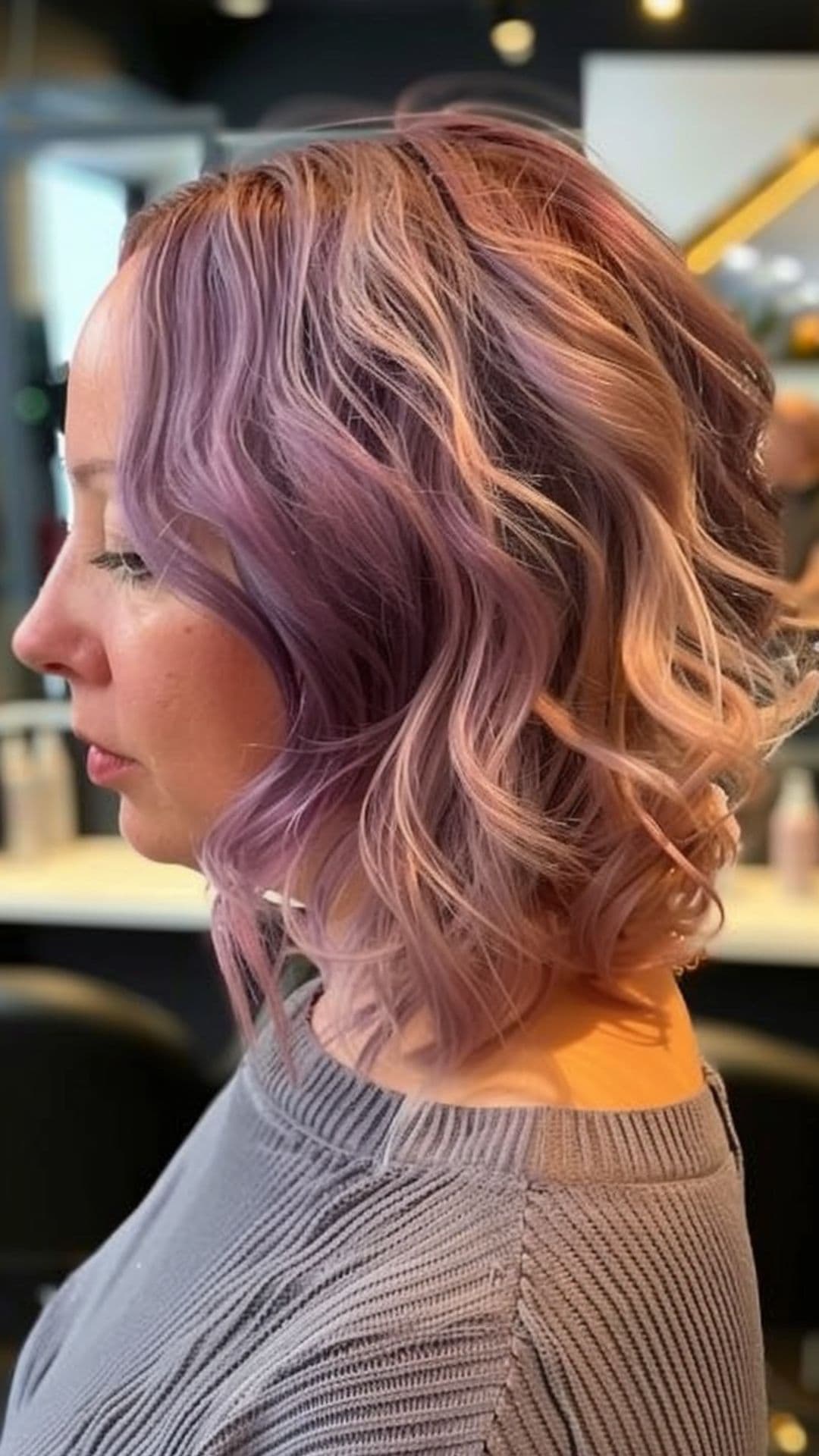 A round-faced woman modelling a pastel purple textured bob hair.