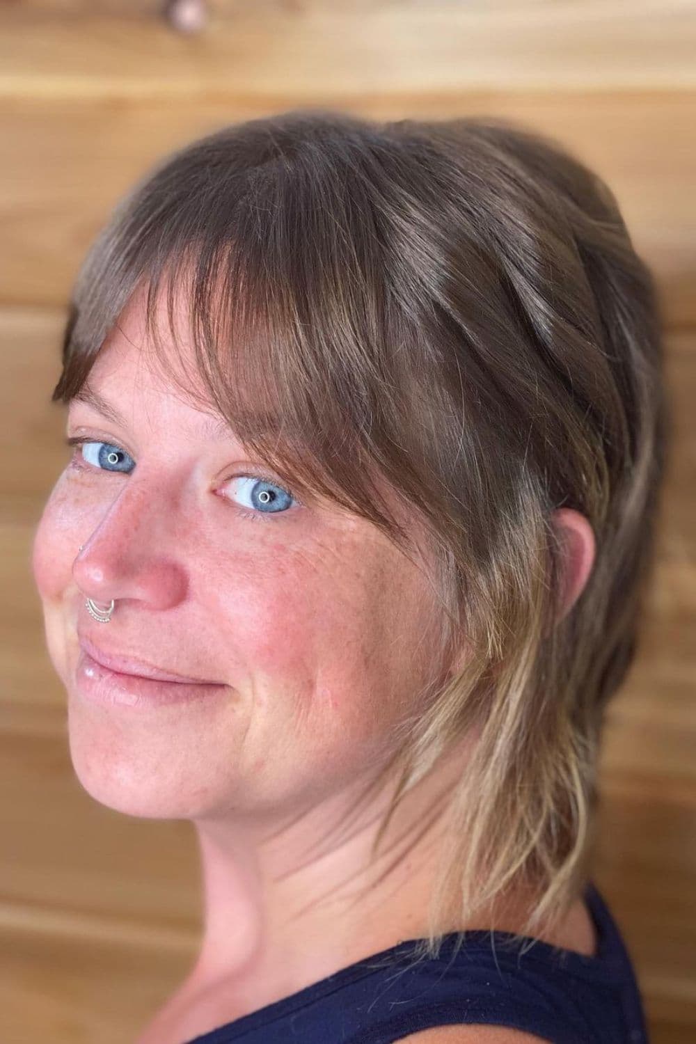 Close-up shot of a woman with a blonde pixie wolf cut.