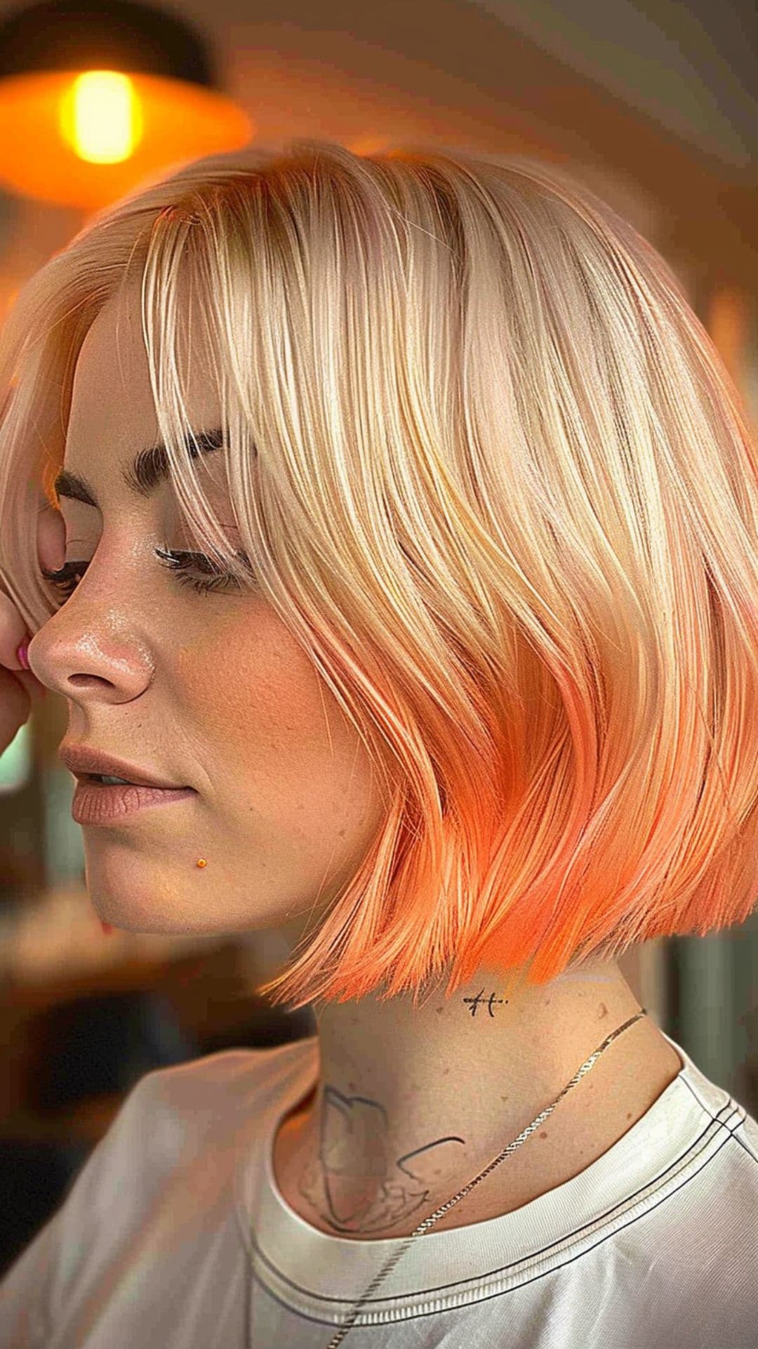 A woman modelling a platinum to peach ombre hair.