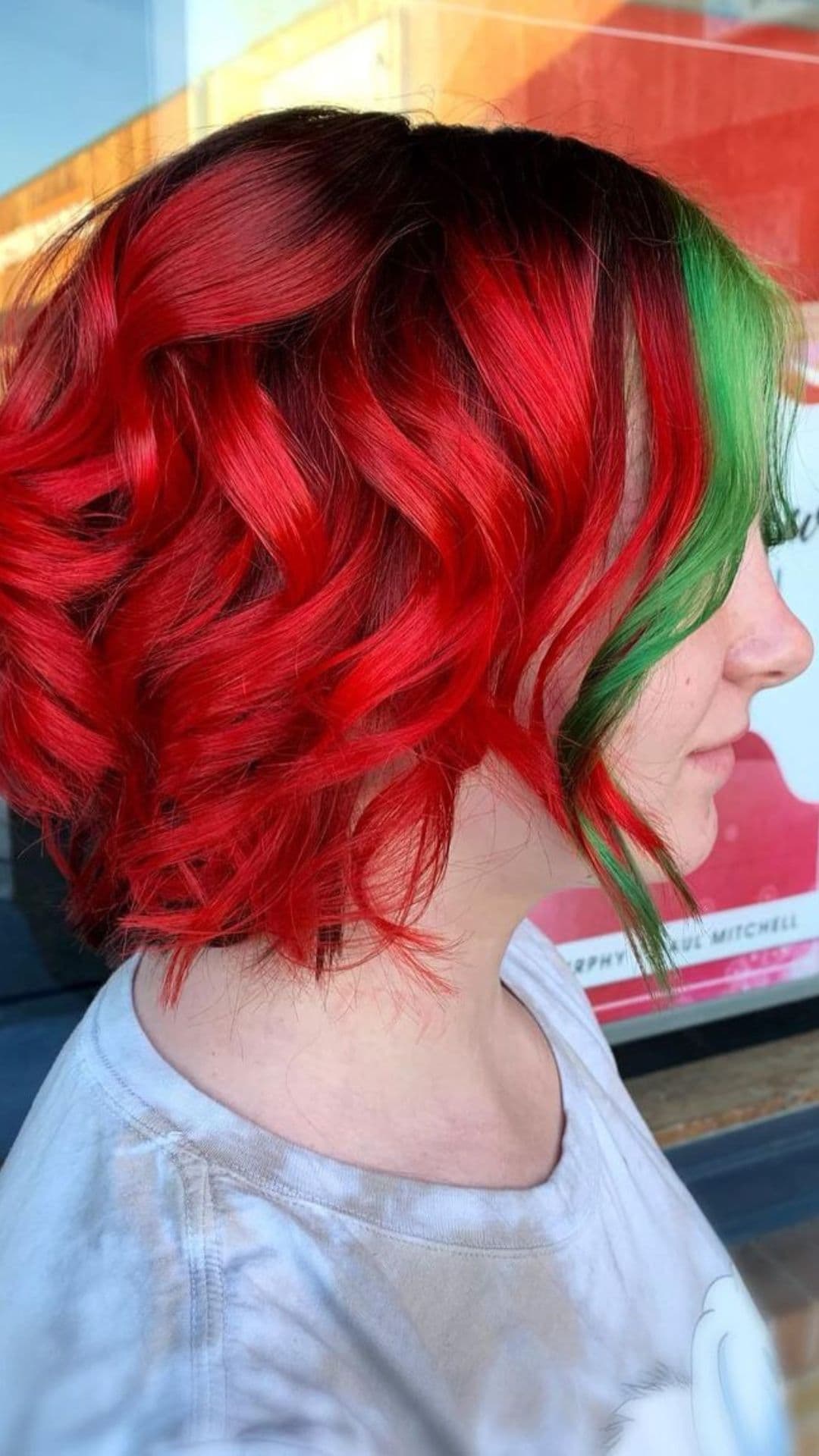 A woman modelling a Red Curly Bob with Green Moneypiece hairstyle.