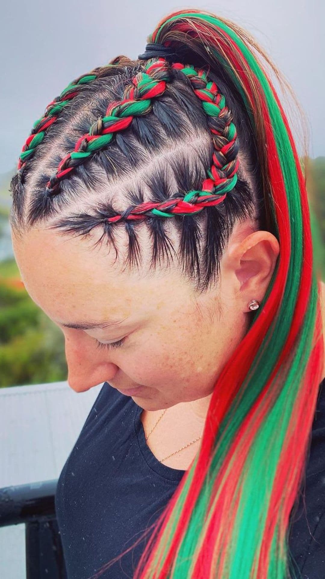 A woman modelling a Red and Green Dutch Braid Ponytail hairstyle.