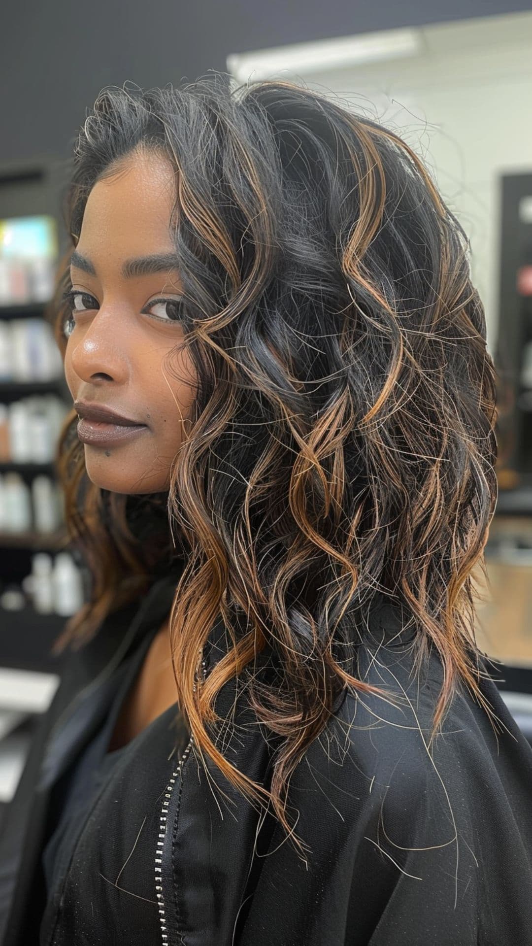 A woman modelling a black hair with caramel highlights.