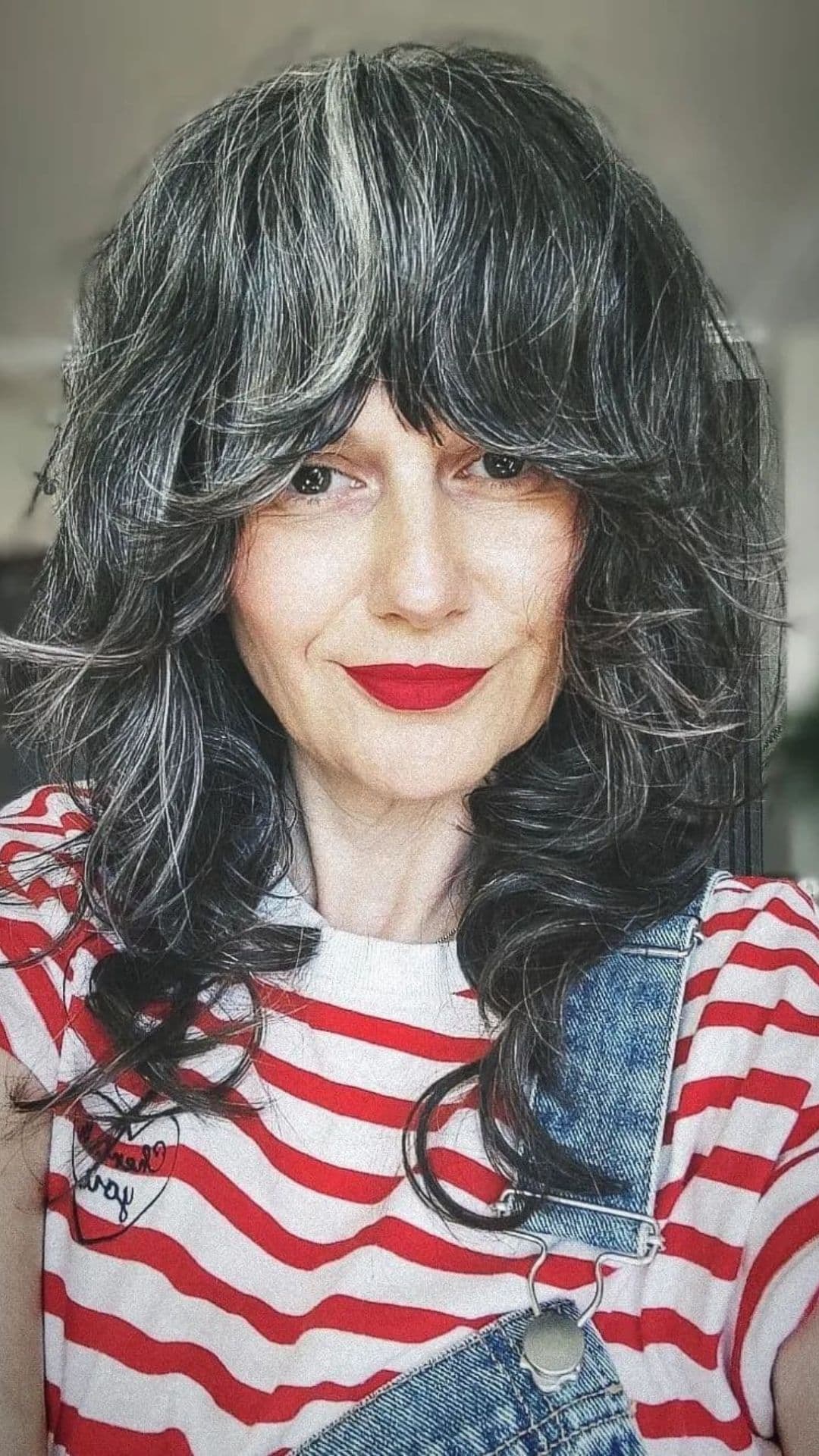 An older woman modelling a salt and pepper medium shag hairstyle.