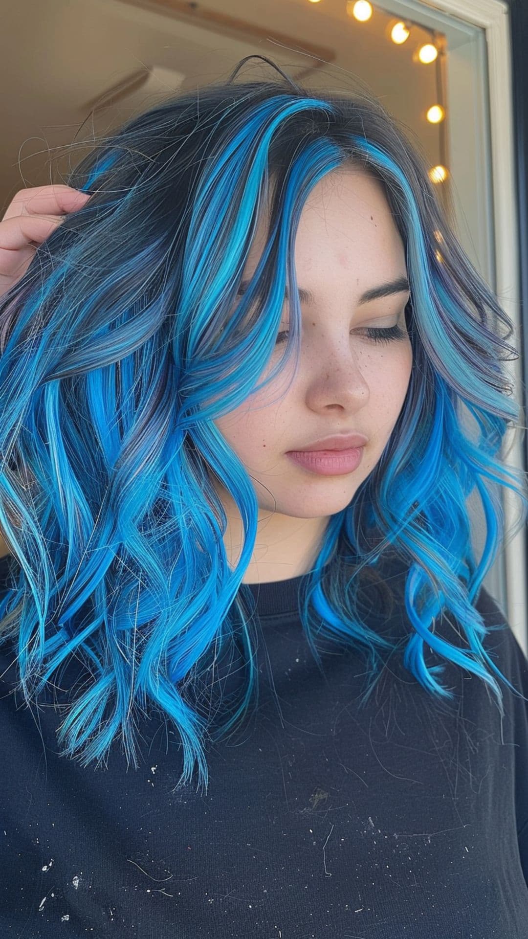 A woman modelling a sapphire blue chunky highlights hair.