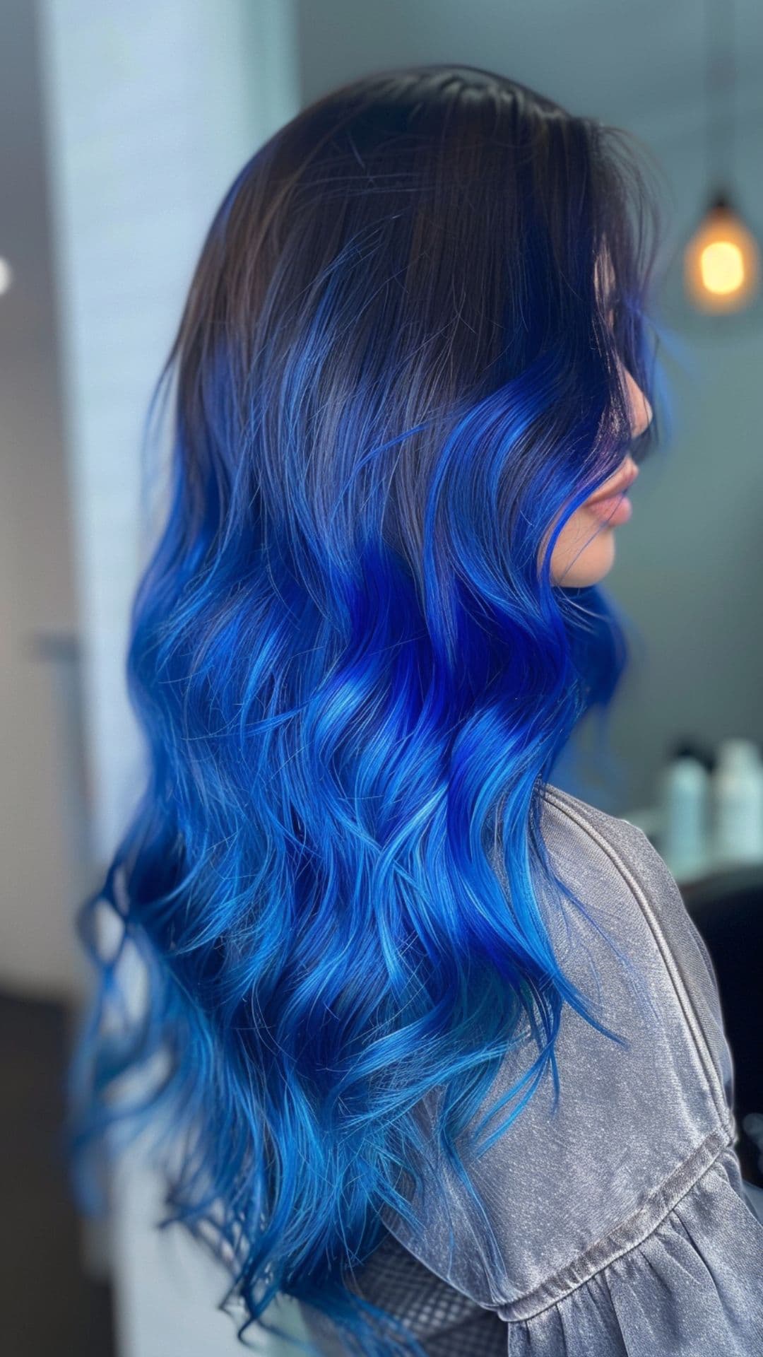 A woman modelling a black to sapphire blue ombre hair.