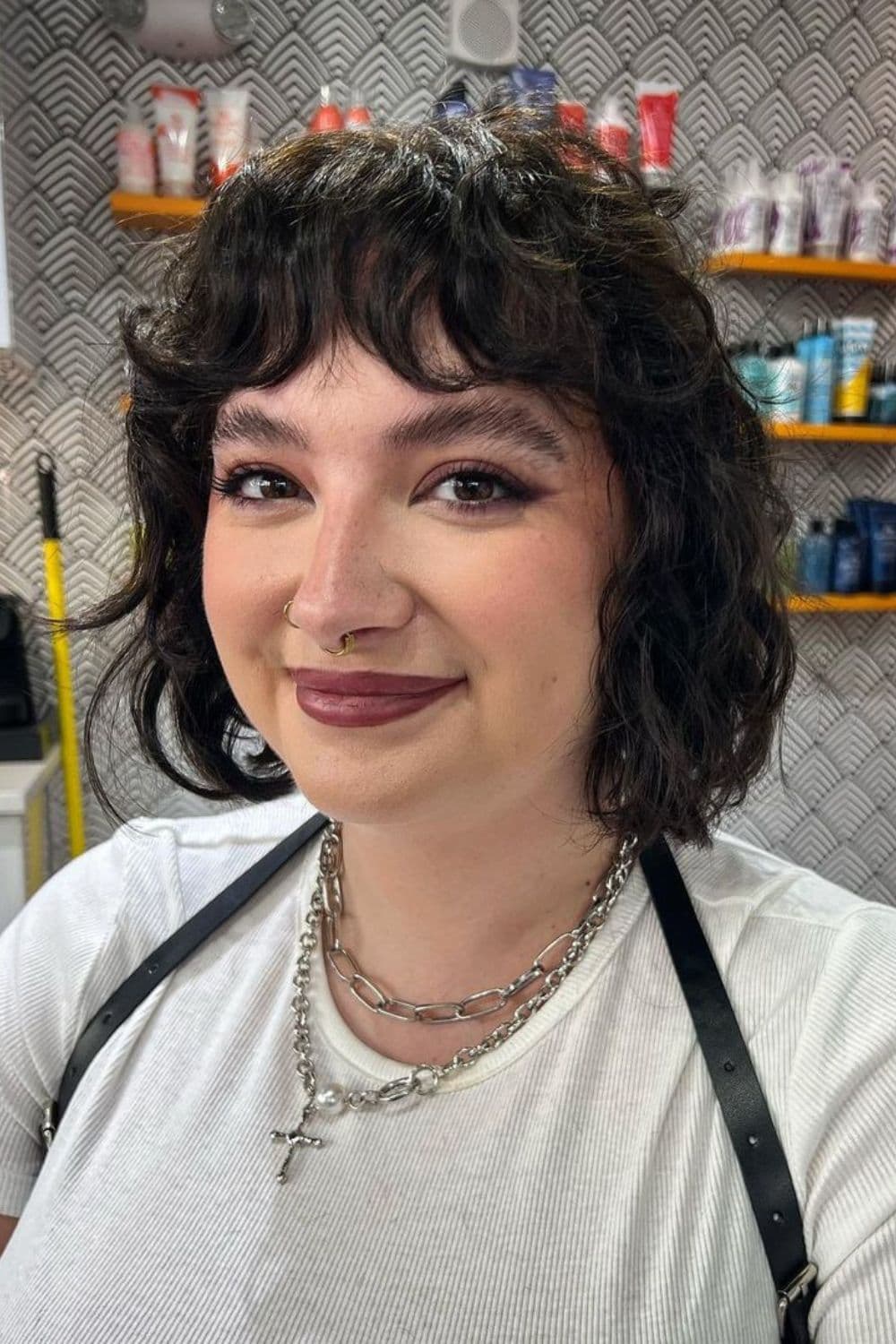 A woman with black wavy shaggy bob cut.