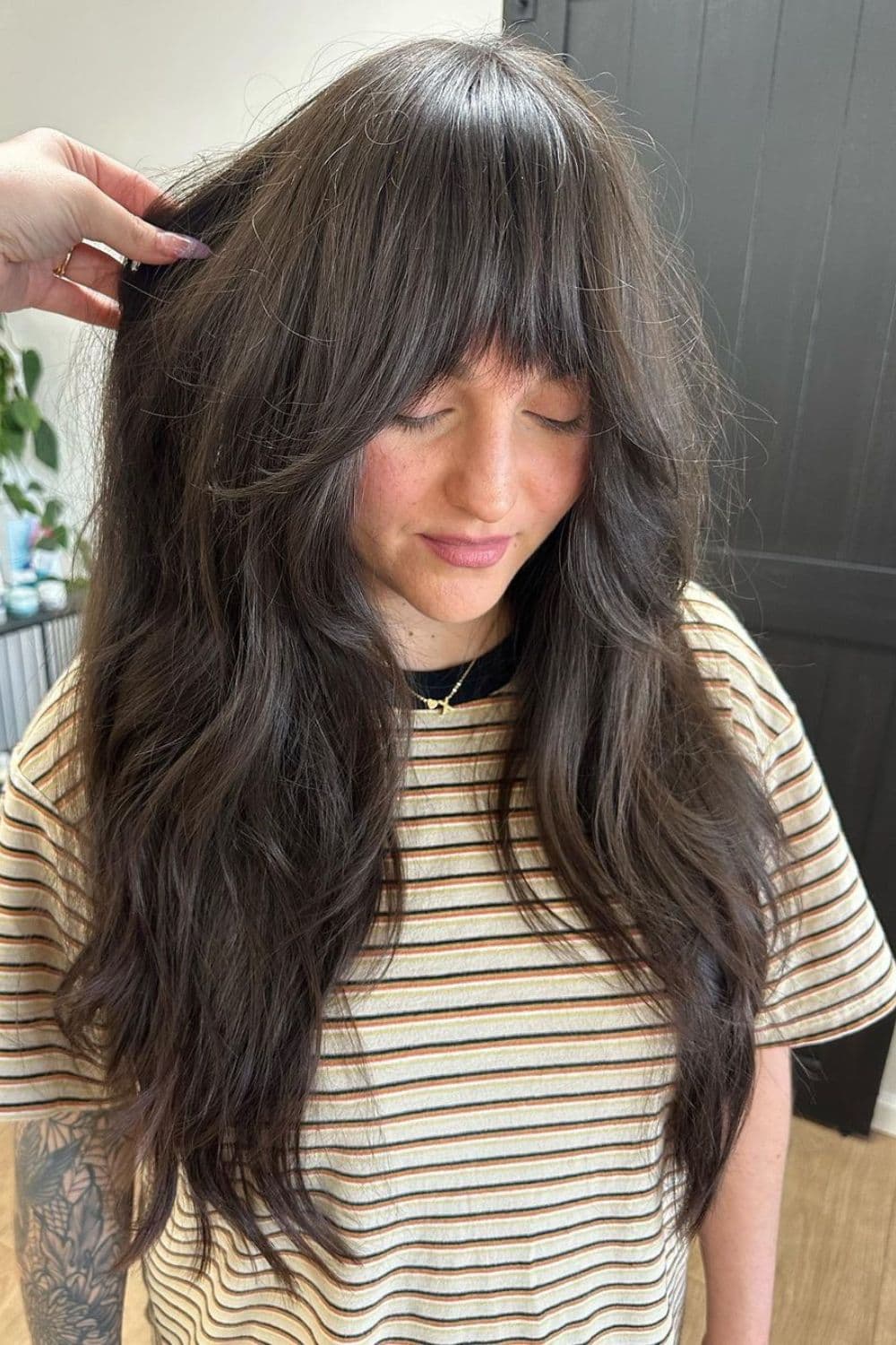 A woman with black, wavy shaggy layers.