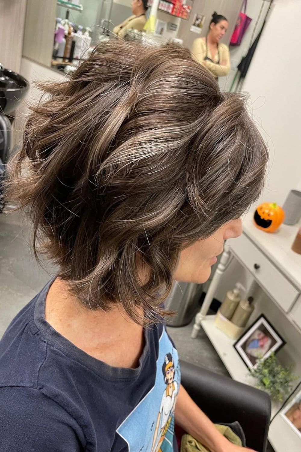 Side view of a woman with shattered wavy bob cut.